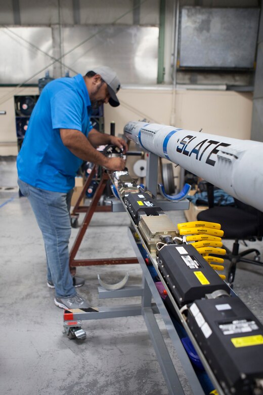 Raul Mendoza, with the Cubic Corporation, works on the Secure Live Virtual Constructive Advanced Training Environment (SLATE) LVC Pod during a demonstration at Nellis Air Force Base, Nevada. (U.S. Air Force photo / William Graver)