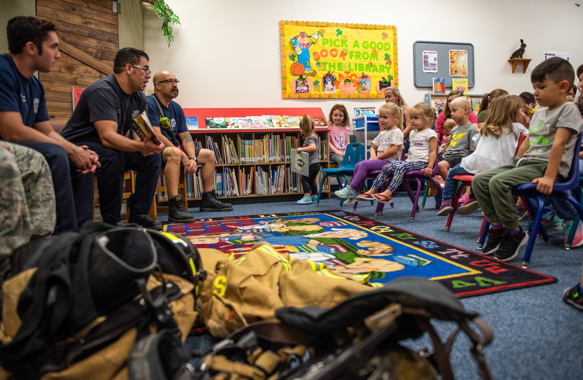 56th Civil Engineer Squadron firefighters read a book to children at the base library as part of Fire Prevention Week Oct. 3, 2018, at Luke Air Force Base, Ariz. The goal of Fire Prevention Week is to help others recognize proper preventative measures they can take in order to be better prepared in the event of a fire emergency. (U.S. Air Force photo by Senior Airman Alexander Cook)