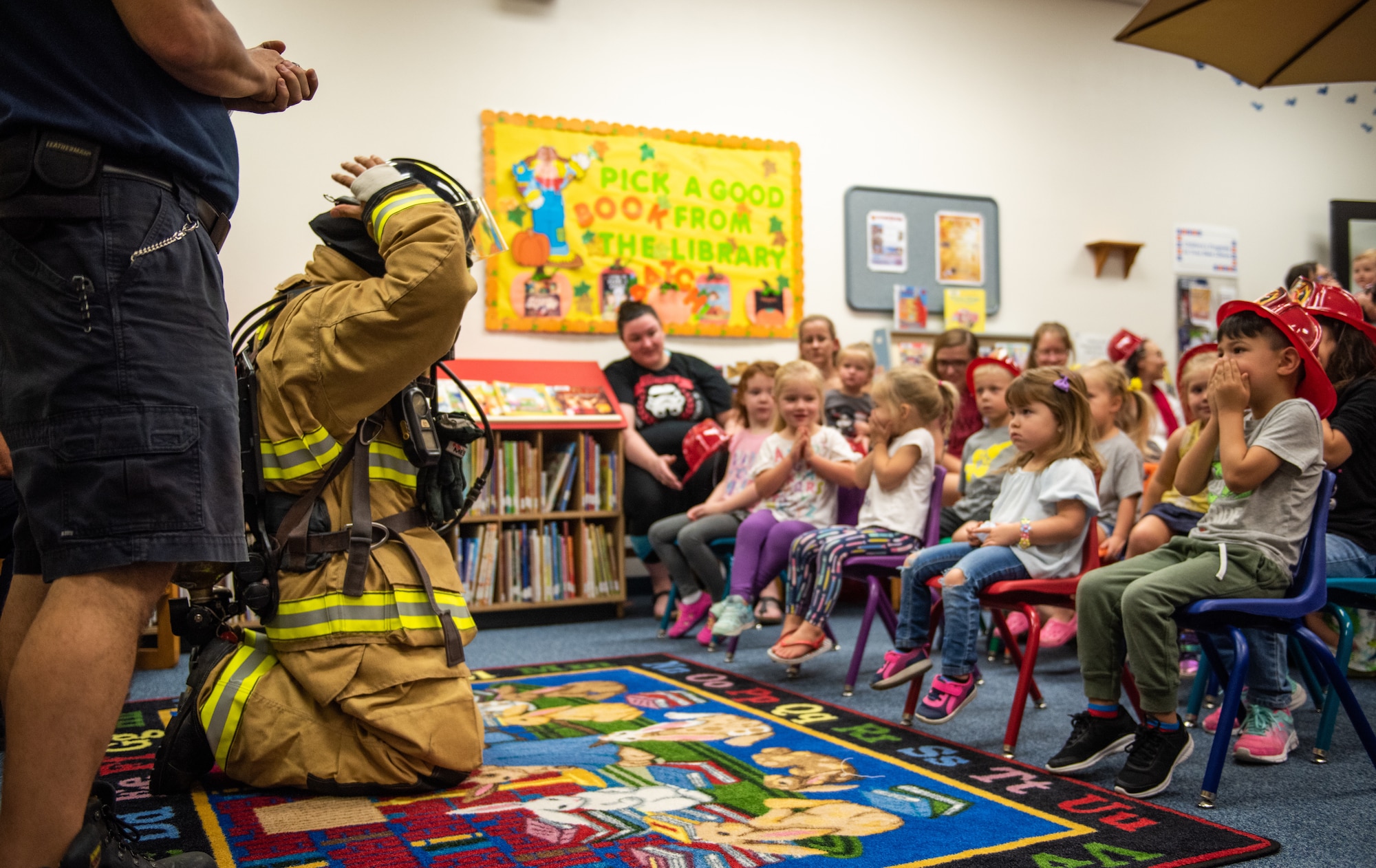 Luke Air Force Base firefighters demonstrate the proper wear of firefighting equipment during their visit to the base library as part of Fire Prevention Week Oct. 3, 2018, at Luke AFB, Ariz. Throughout Fire Prevention Week, activities will be held on base for Airmen and their families to receive information on preventative measures they can take to exercise fire safety. (U.S. Air Force photo by Senior Airman Alexander Cook)