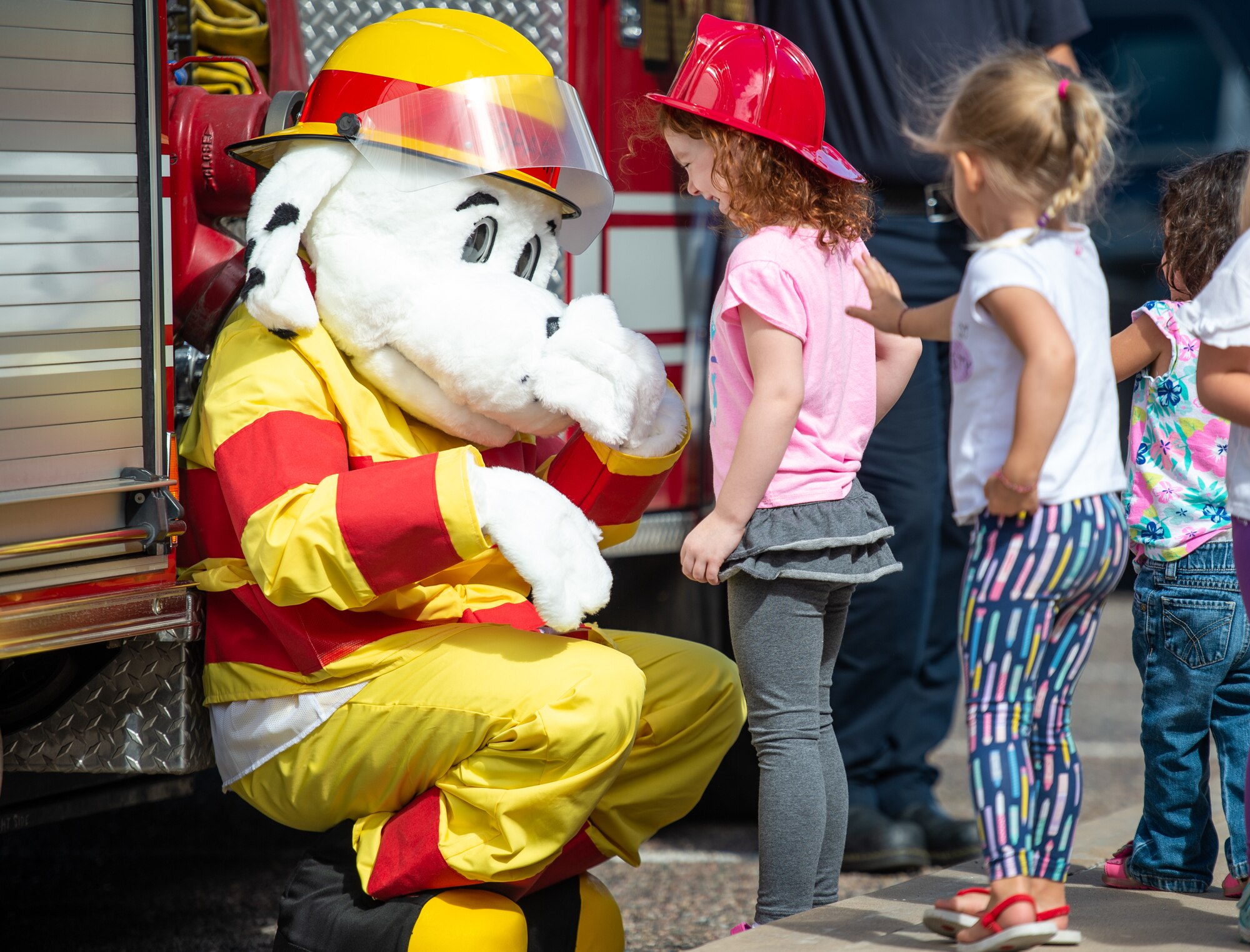 Children interact with “Sparky the Fire Dog” during a visit to the base library as part of Fire Prevention Week Oct. 3, 2018, at Luke Air Force Base, Ariz. This year’s key message for Fire Prevention Week is, look, listen, and learn. (U.S. Air Force photo by Senior Airman Alexander Cook)