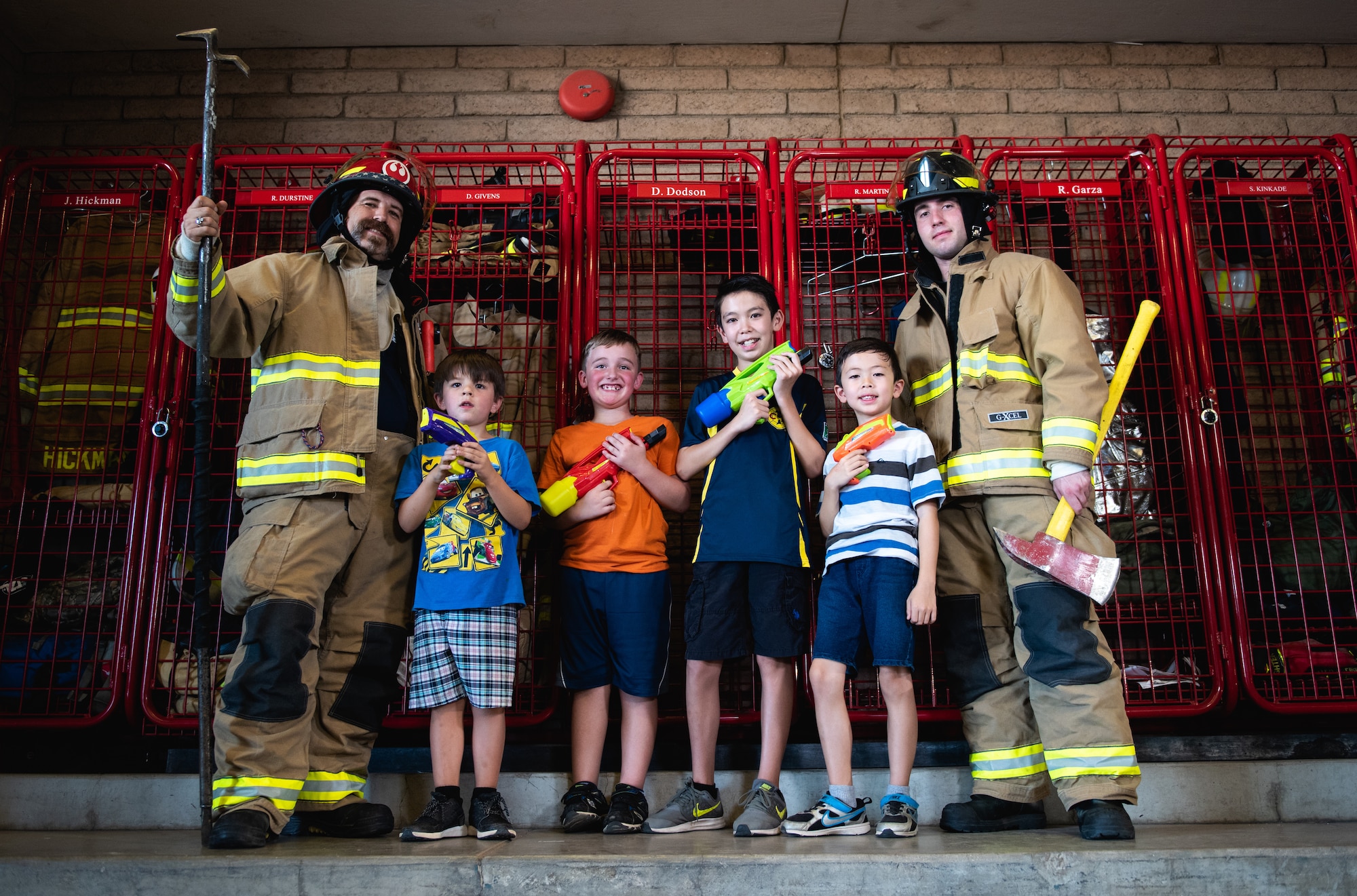 Luke Air Force Base firefighters pose for a photo with children during a visit to the base fire station as part of Fire Prevention Week Oct. 3, 2018, at Luke AFB, Ariz. This year’s theme for Fire Prevention Week encourages children to go toward a fire fighter during the event of a fire and not hide. (U.S. Air Force photo by Senior Airman Alexander Cook)