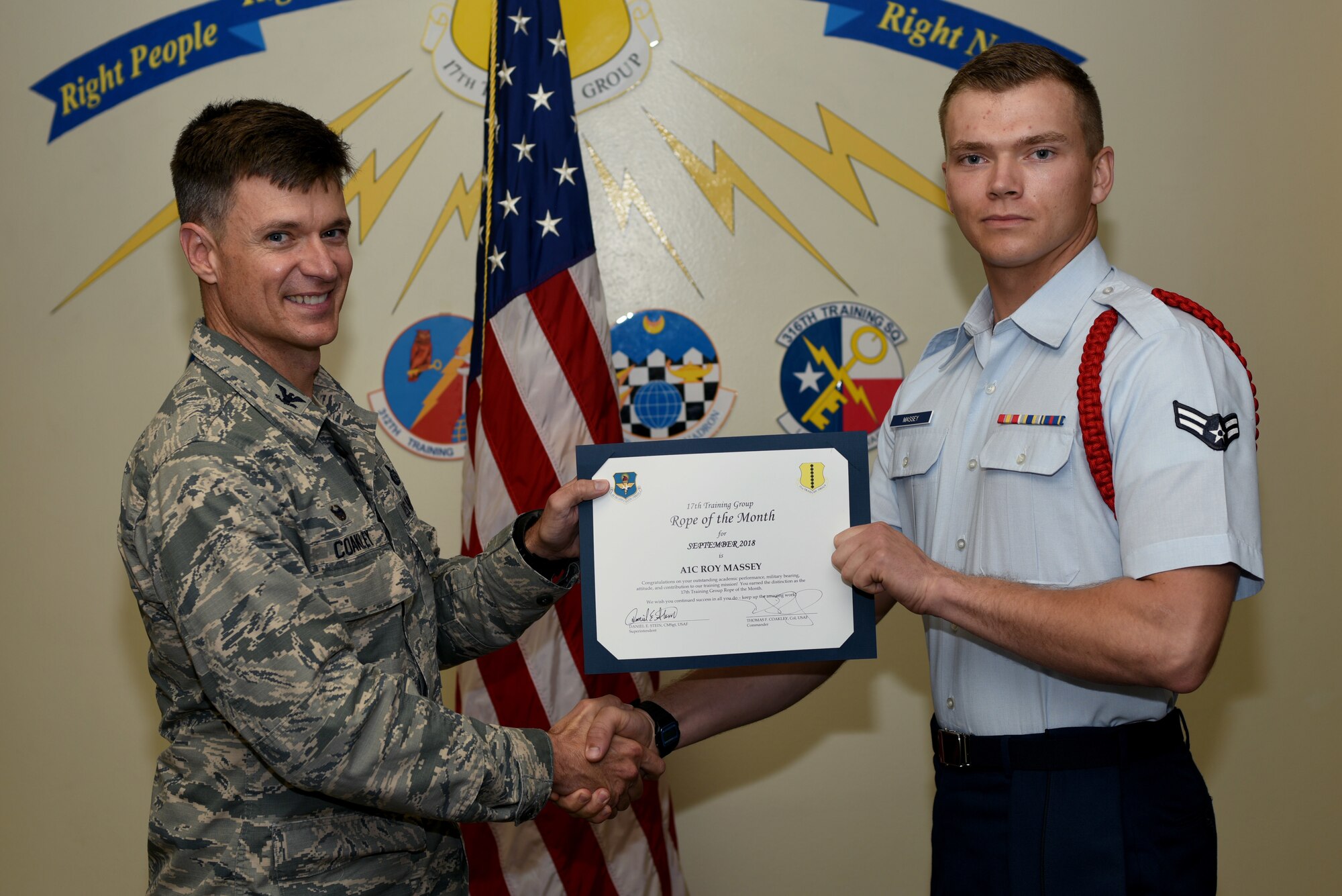 U.S. Air Force Col. Thomas Coakley, 17th Training Group commander, presents the 17th TRG Rope of the Month award to Airman 1st Class Roy Massey, 315th Training Squadron student, at Brandenburg Hall on Goodfellow Air Force Base, Texas, Oct. 5, 2018. Military Training Leaders present ropes to Airmen who display exceptional leadership qualities to lead their peers. (U.S. Air Force photo by 2nd Lt. Matthew Stott /Released)