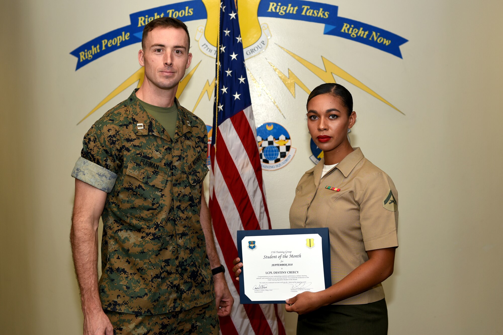 U.S. Marine Corps Capt. Jason Furman, Marine Corps Detachment at Goodfellow executive officer, presents the 316th Training Squadron Student of the Month award to Lance Cpl. Destiny Creecy, Marine Corps Detachment at Goodfellow student, at Brandenburg Hall on Goodfellow Air Force Base, Texas, Oct. 5, 2018. The 316th TRS’s mission is to conduct U.S. Air Force, U.S. Army, U.S. Marine Corps, U.S. Navy and U.S. Coast Guard cryptologic, human intelligence and military training. (U.S. Air Force photo by 2nd Lt. Matthew Stott/Released)