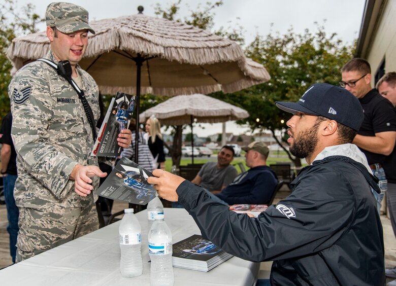 Bubba Wallace, driver of the No. 43 World Wide Technology Chevrolet in the Monster Energy NASCAR Cup Series, hands an autographed information card to Tech. Sgt. Scott Morisette, 436th Civil Engineer Squadron fire department station chief, during the NASCAR Social Oct. 5, 2018, at The Landings on Dover Air Force Base, Del. Wallace and several other NASCAR drivers visited the free event to meet with Team Dover members and show support for military families. (U.S. Air Force photo by Roland Balik)