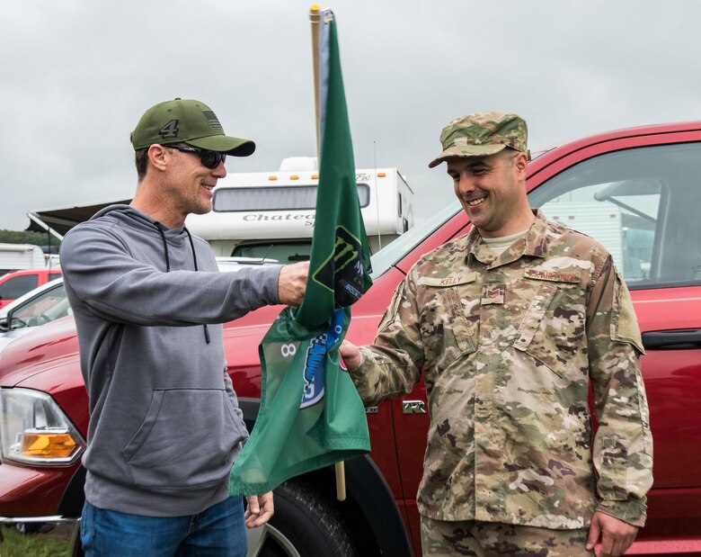 Kevin Harvick, driver of the No. 4 Busch Outdoors Ford in the Monster Energy NASCAR Cup Series, surprises Tech. Sgt. Michael Kelly, 736th Aircraft Maintenance Squadron C-17 Globemaster III flight line expediter, with the green flag Oct. 6, 2018, at Dover International Speedway in Dover, Del. Kelly was selected as the honorary starter for the "Gander Outdoors 400" Monster Energy NASCAR Cup Series race on Oct. 7. (U.S. Air Force photo by Roland Balik)