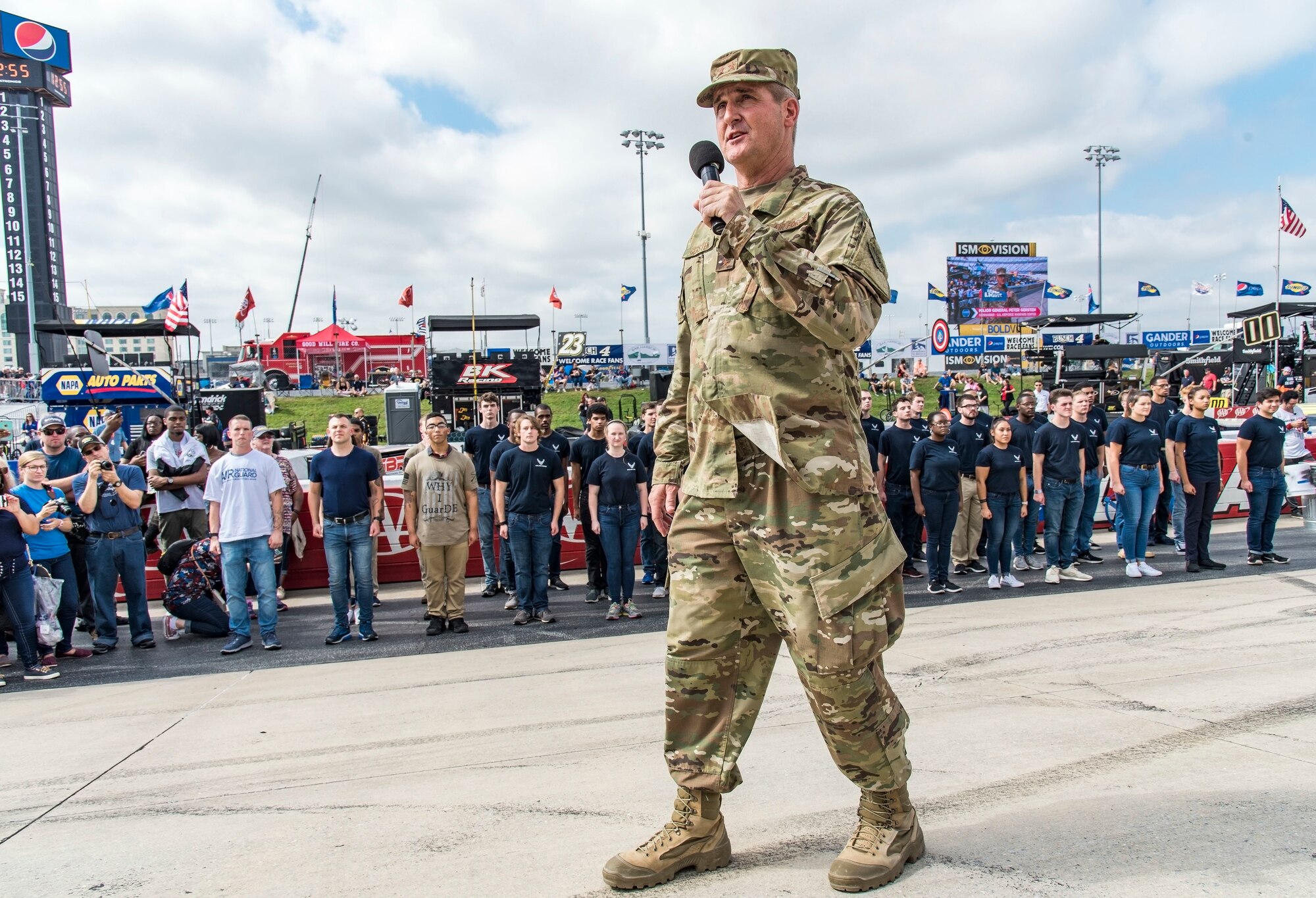 Maj. Gen. Peter Gersten, U.S. Air Force Warfare Center commander, Nellis Air Force Base, Nev., speaks to race attendees before issuing the oath of enlistment for Air Force recruits and prior to the start of the "Gander Outdoors 400" Monster Energy NASCAR Cup Series race Oct. 7, 2018, at Dover International Speedway in Dover, Del. Forty-two recruits joined the U.S. Air Force, Delaware National Guard and Air National Guard through the Delayed Entry Program. Under the DEP, individuals going onto active duty, enlist first into the DEP. This is an actual enlistment into the inactive Reserves, with an agreement to report for active duty to attend basic military training at a specific time in the future. (U.S. Air Force photo by Roland Balik)