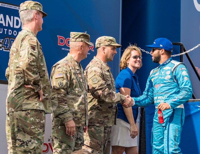 Bubba Wallace, driver of the No. 43 World Wide Technology Chevrolet in the Monster Energy NASCAR Cup Series, shakes hands with Tech. Sgt. Michael Kelly, 736th Aircraft Maintenance Squadron C-17 Globemaster III flight line expediter, during driver introductions Oct. 7, 2018, at Dover International Speedway in Dover, Del. Kelly was selected as the honorary starter for the "Gander Outdoors 400" Monster Energy NASCAR Cup Series race. (U.S. Air Force photo by Roland Balik)