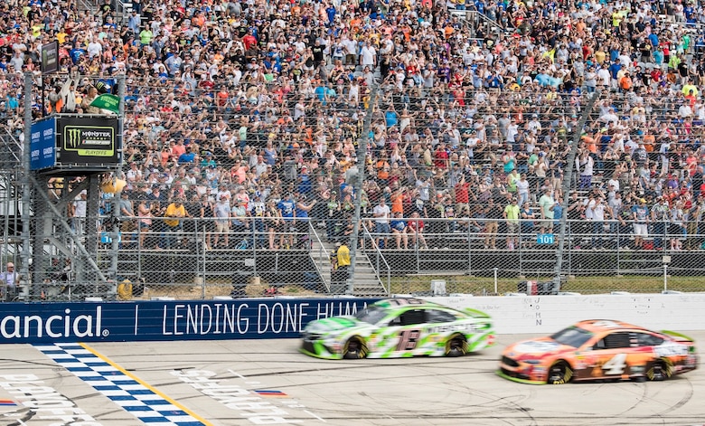 Tech. Sgt. Michael Kelly (top left), 736th Aircraft Maintenance Squadron C-17 Globemaster III flight line expediter, waves the green flag for the start of the "Gander Outdoors 400" Monster Energy NASCAR Cup Series race Oct. 7, 2018, at Dover International Speedway in Dover, Del. Kelly waved the flag as the row one cars, No. 18 Kyle Busch and No. 4 Kevin Harvick, head to the starting line. (U.S. Air Force photo by Roland Balik)