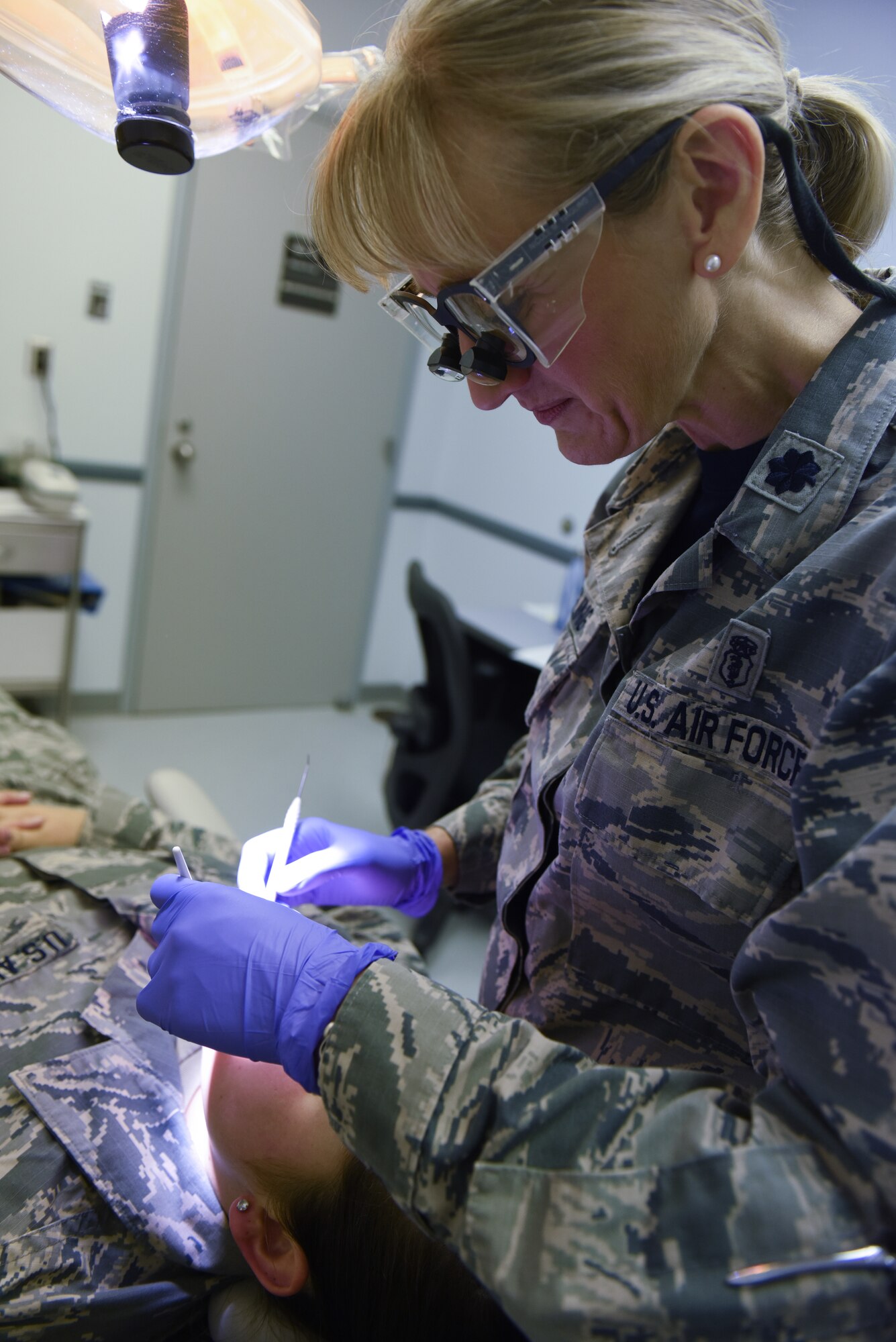 Lt. Col. Nicole Yingling, a dentist with the 193rd Special Operations Medical Group, Middletown, Pennsylvania, performs a routine checkup on an Airman Sept. 22, 2018. Yingling served 11 years as an active duty dentist and after a 12-year break-in-service, enlisted into the 193rd SOMDG. (U.S. Air National Guard photo by Senior Airman Julia Sorber/Released)
