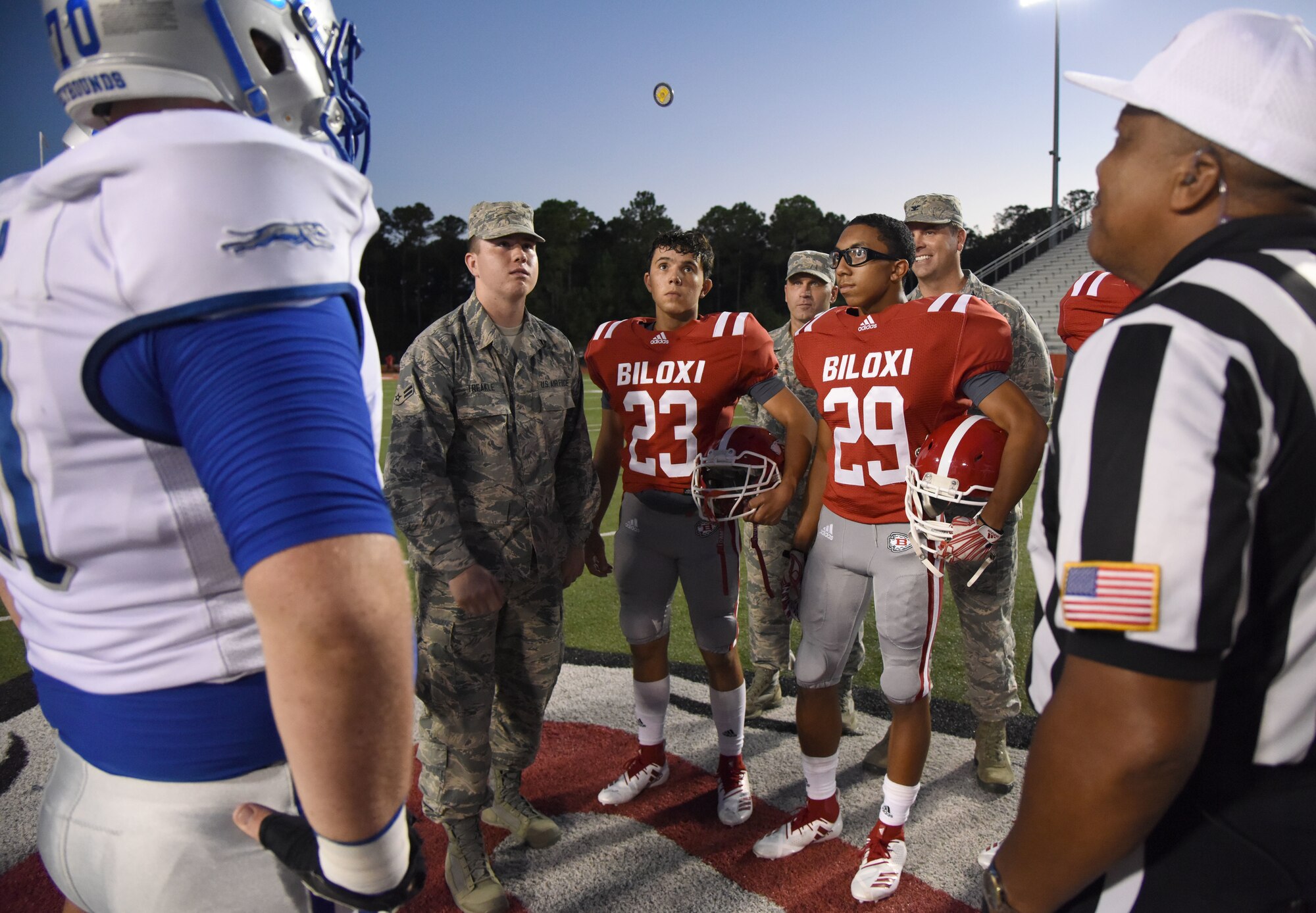 U.S. Air Force Airman 1st Class Mark Treakle, 338th Training Squadron student, and Keesler leadership participate in the coin toss to determine which team would receive the ball first during a Biloxi High School military appreciation night football game in Biloxi, Mississippi, Oct. 5, 2018. Treakle is a 2018 graduate of BHS. Keesler Airmen also participated in other pre-game festivities such as holding the U.S. Flag during the playing of the national anthem. (U.S. Air Force photo by Kemberly Groue)