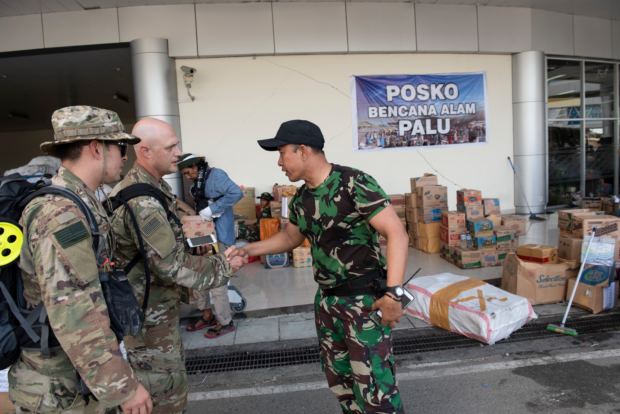 U.S. Air Force Lt. Col. Aaron Lane, 36th Mobility Readiness Squadron commander, Maj. Sean Conley, 36th MRS operations officer, both assigned to the 36th Contingency Response Group Andersen Air Force Base, Guam, are greeted by an Indonesian military member in Palu, Indonesia Oct. 6, 2018. The purpose of the visit was to establish an initial baseline of how to best support our Indonesian counterparts. (U.S. Air Force photo by Master Sgt. JT May III)