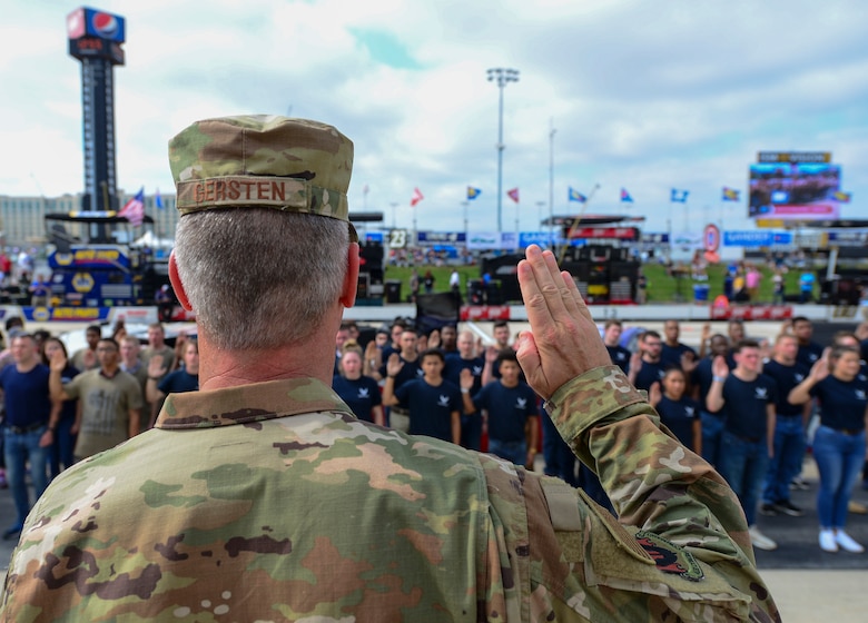 Maj. Gen. Peter Gersten, U.S. Air Force Warfare Center commander, Nellis Air Force Base, Nev., administers the oath of enlistment for more than 40 enlistees in the Air Force Delayed Entry Program prior to the start of the “Gander Outdoors 400” Monster Energy NASCAR Cup Series race Oct. 7, 2018, at the Dover International Speedway in Dover, Del. This is one of the first steps these recruits will take to enter the United States Armed Forces. (U.S. Air Force photo by Airman First Class Dedan D. Dials)