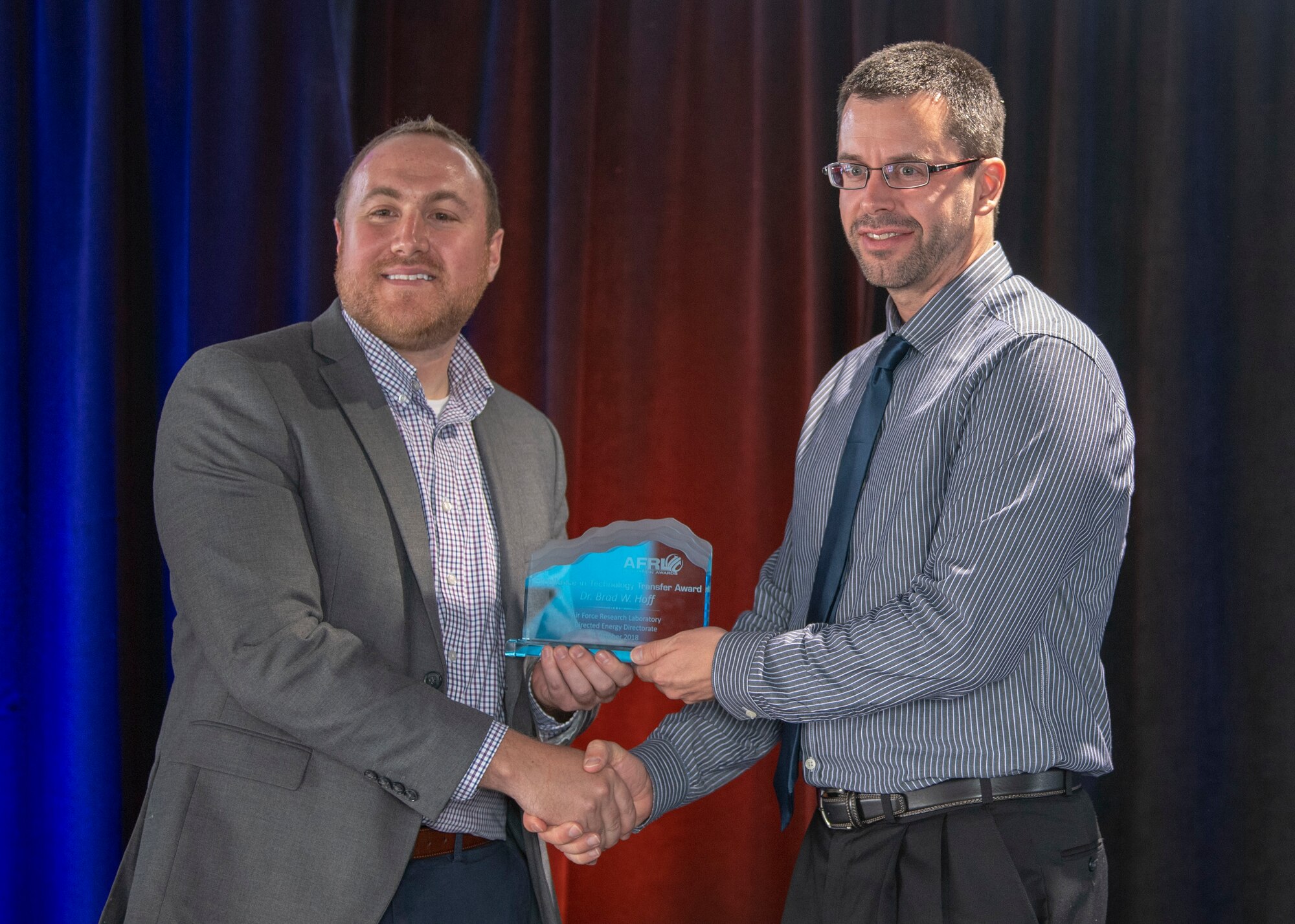 Brad Hoff, Directed Energy Directorate senior research physicist, poses with Matt O'Brien, Air Force Research Lab technology transfer program manager, after receiving the Excellence in Tech Transfer award at the Air Force Research Lab’s Innovation Awards at the Lobo Rainforest Building at Innovate ABQ, in Albuquerque, N.M., Oct. 4, 2018. The Innovation Awards highlight AFRL innovators, inventors, discoverers, experts in tech transfer, collaborative transfer, trademarks and patent recipients from the U.S. Patent office. (U.S. Air Force photo by Staff Sgt. JD Strong II)