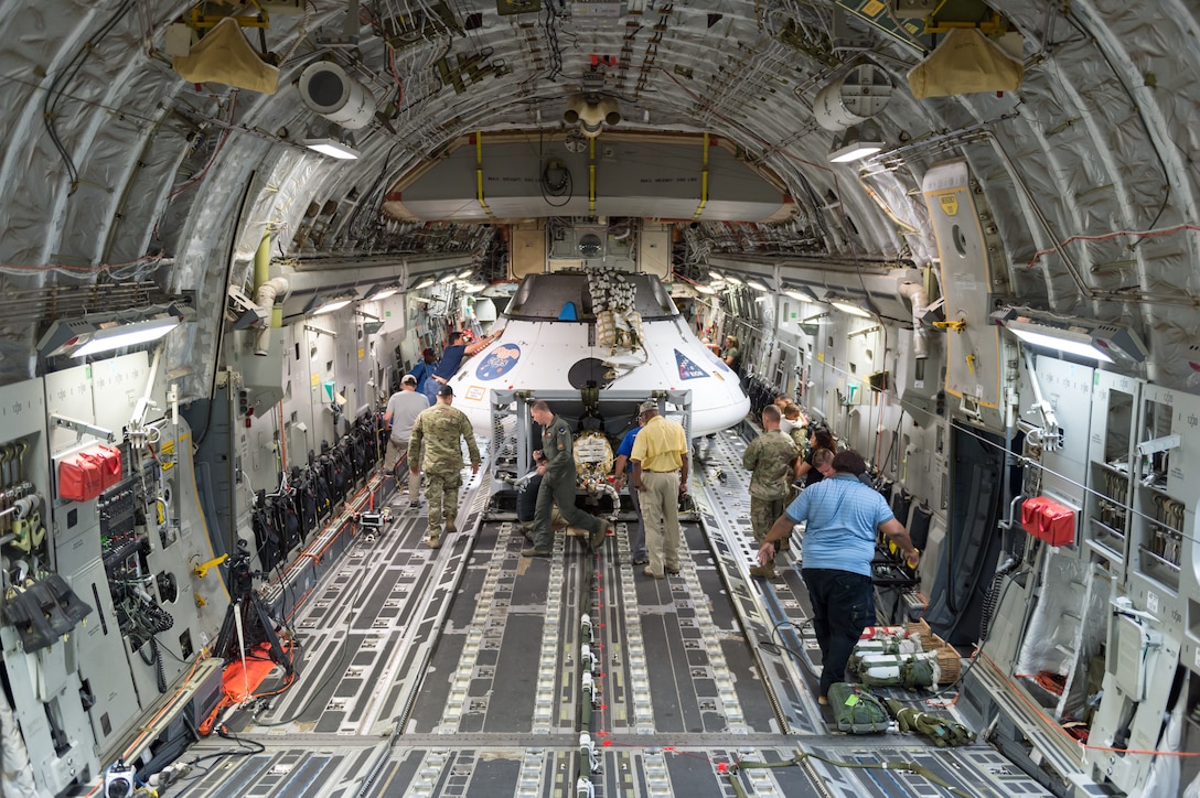 A team of NASA, U.S. Army and 418th Flight Test Squadron personnel secure the NASA Orion test capsule in the cargo area of C-17 Globemaster III Sept. 10, 2018. The mock capsule was later pulled out the back of the cargo plane Sept. 12 for its final parachute system test over the U.S. Army’s Yuma Proving Ground in Arizona. (U.S. Air Force photo by Kyle Larson)