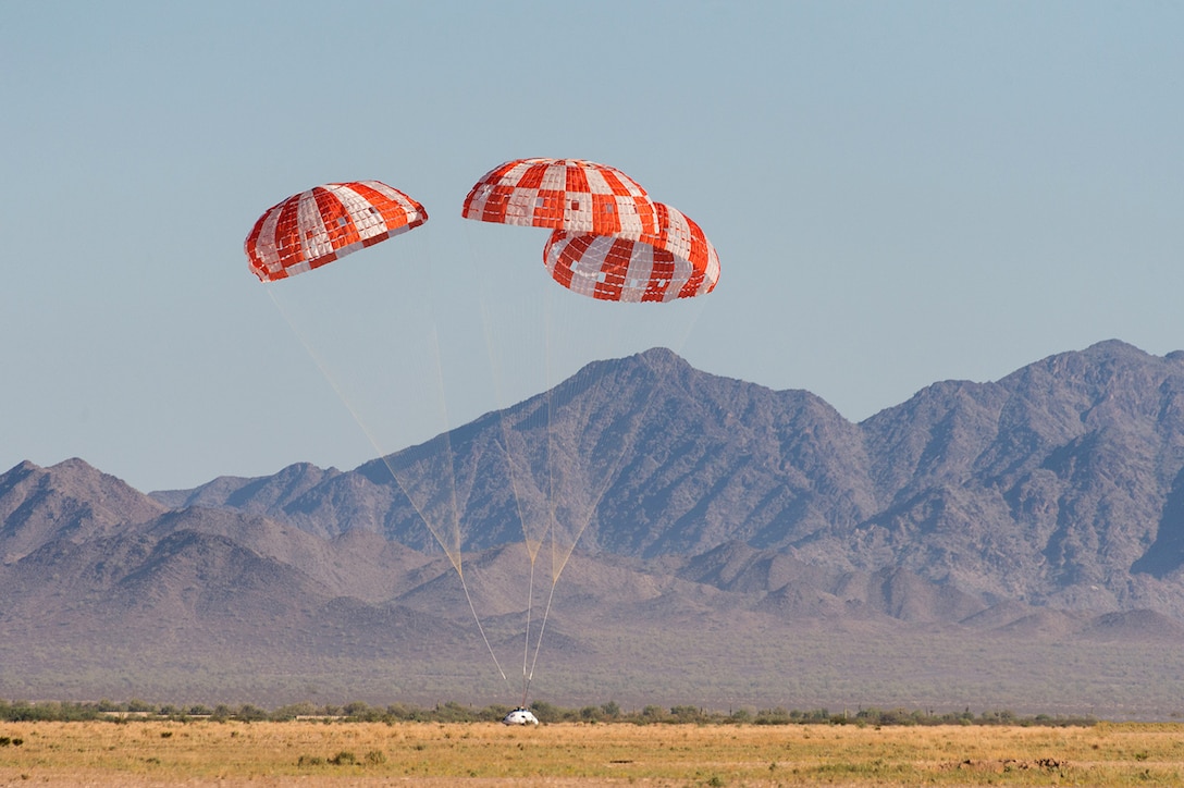 An Orion test capsule with its three main parachutes touches down in the Arizona desert Sept. 12, 2018. The evaluation was the final test to qualify Orion’s parachute system for flights with astronauts. (U.S. Army photo)