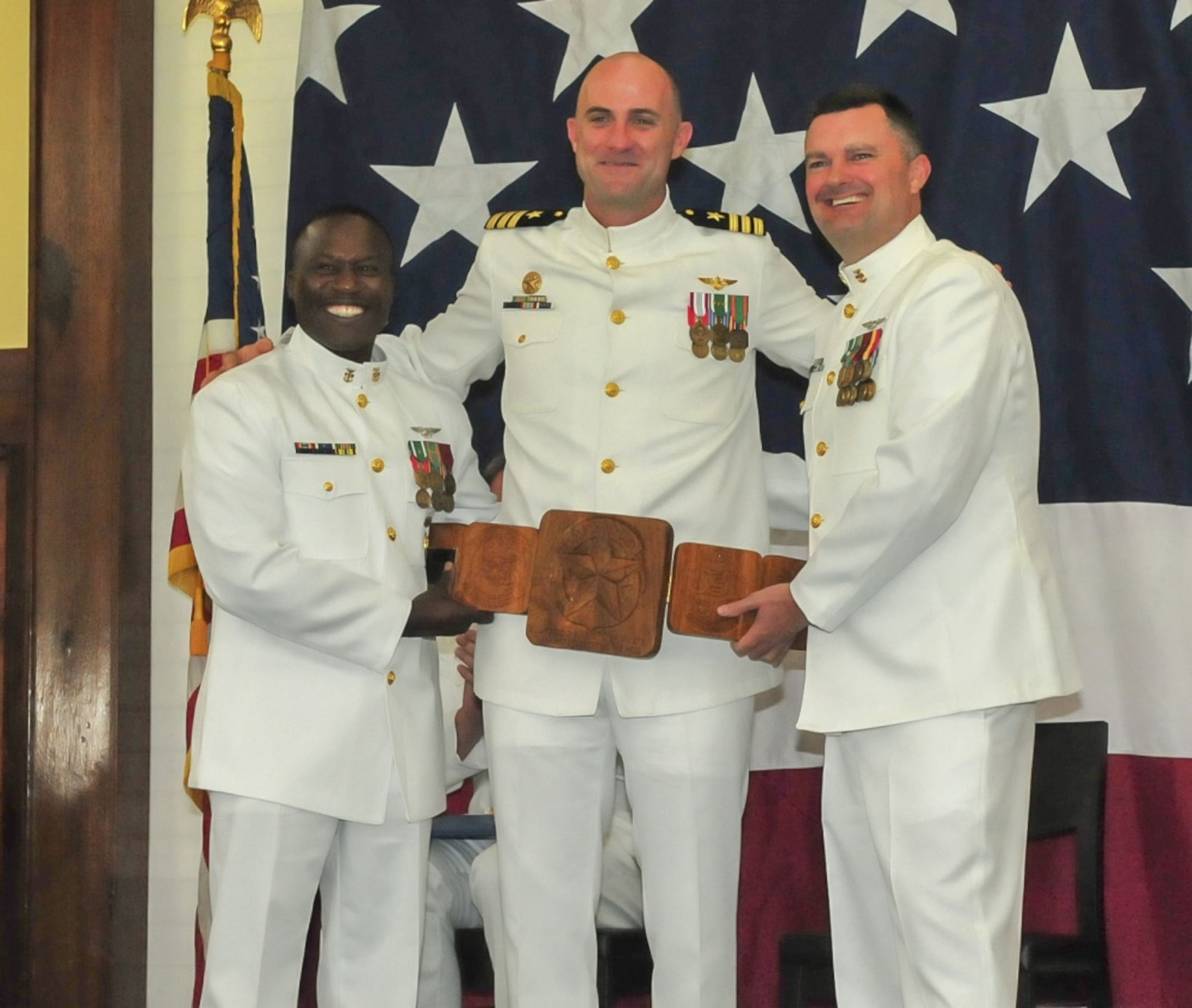 ANDERSEN AIR FORCE BASE, Guam (Oct. 5, 2018) – Helicopter Sea Combat Squadron 25 Command Master Chief Keith Wilkerson, left, and Master Chief Avionics Maintenance Technician John Adams, right, present a plaque to commanding officer Cmdr. William Eastham during the HSC-25 change of command ceremony at the Sunrise Conference Center at Andersen Air Force Base Oct. 5. During the ceremony, Cmdr. Frank Loforti relieved Eastham as commanding officer. (U.S. Navy photo by Alana Chargualaf)