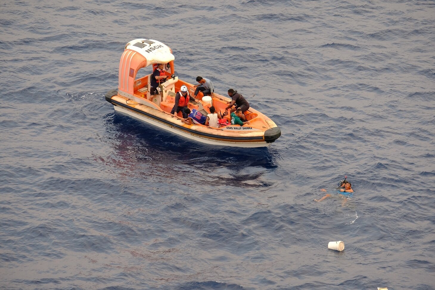 SOUTH CHINA SEA—A search and rescue swimmer from USNS Wally Schirra (T-AKE 8) rescues a fisherman off an adrift and distressed boat in the South China Sea, Oct. 8. Five Filipino fishermen survived for five days aboard a makeshift boat after their fishing boat sank at sea and they were rescued by the crew of USNS Wally Schirra.