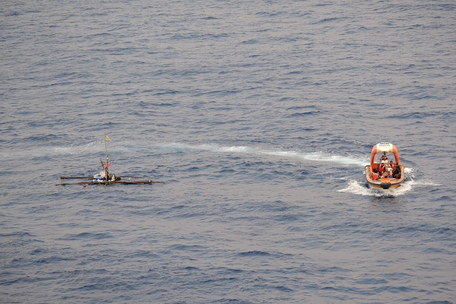 SOUTH CHINA SEA—A rigid-hulled, inflatable boat deployed off the USNS Wally Schirra (T-AKE 8) circles a distressed and adrift boat in the South China Sea, Oct. 8. Five Filipino fishermen survived for five days aboard a makeshift boat after their fishing boat sank at sea and they were rescued by the crew of USNS Wally Schirra.