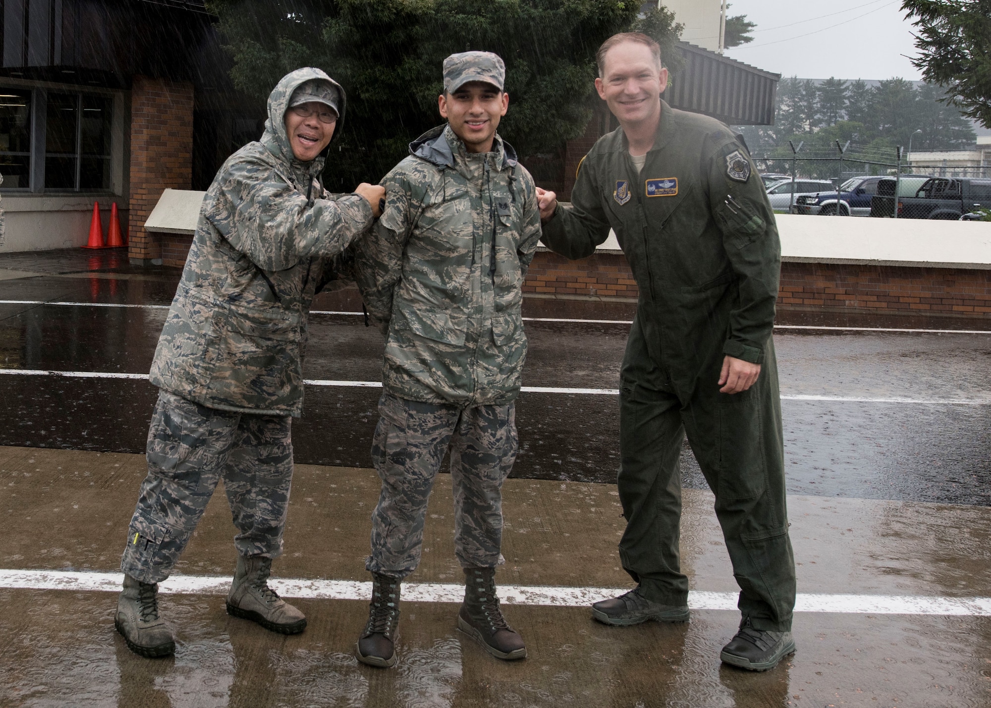U.S. Air Force Maj. David Suh, left, a 35th Fighter Wing chaplain, and Col. Kristopher Struve, right, the 35th FW commander, tack on stripes for Tech. Sgt. Chris Jeffers, center, the 35th FW Chapel resource management NCO in charge, during a wing-wide foreign object and debris walk at Misawa Air Base, Japan, Sept. 10, 2018. The STEP program provides slots to Air Force major commands to immediately promote Airmen to staff sergeant, technical sergeant or master sergeant. (U.S. Air Force photo by Airman 1st Class Collette Brooks)