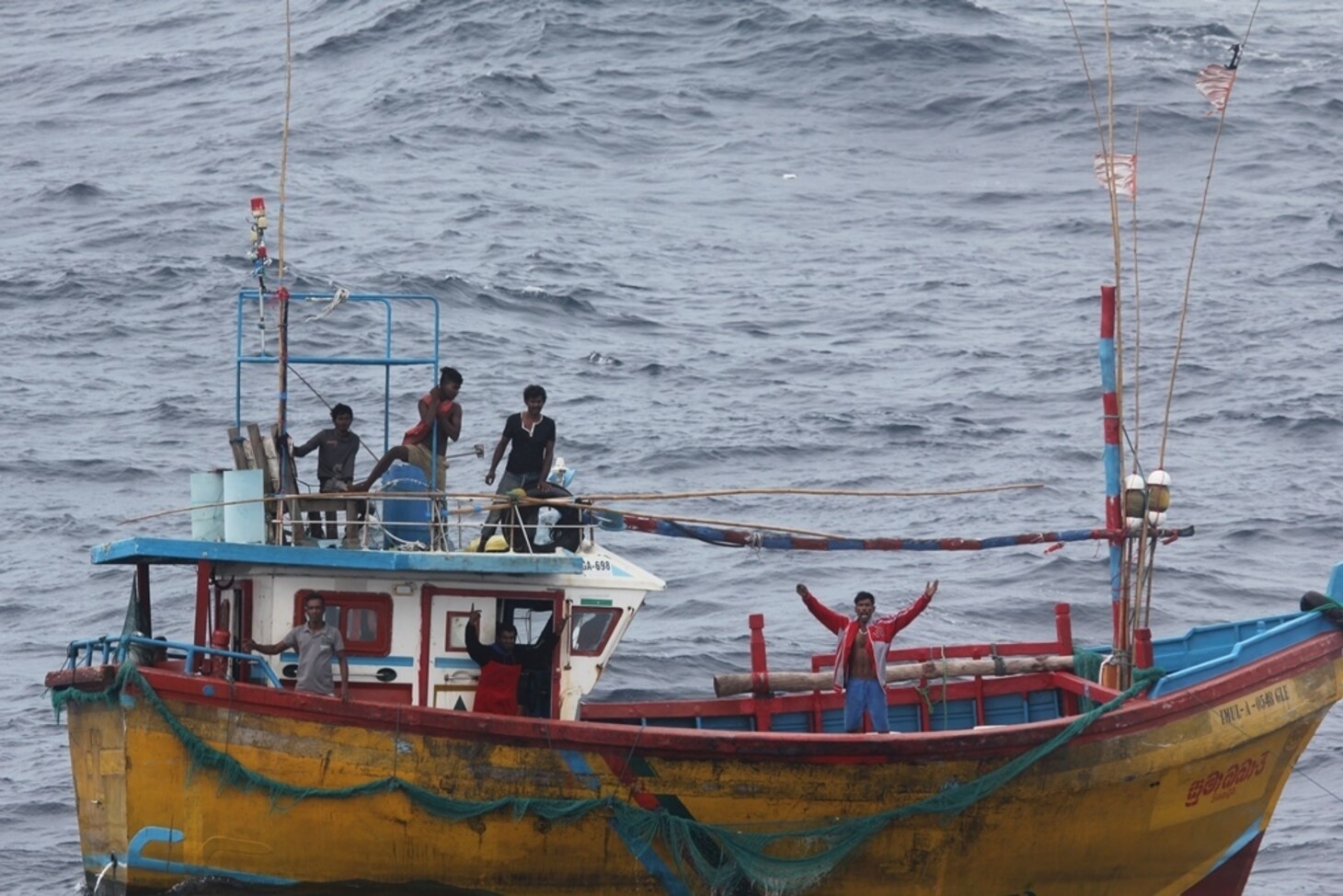 INDIAN OCEAN (Oct. 7, 2018) Stranded Sri Lankan fisherman signal the Arleigh Burke-class guided missile destroyer USS Decatur (DDG 73) for assistance. After providing food and water, Decatur contacted the Sri Lankan authorities who came and towed the stranded vessel back to port. Decatur is forward deployed to the U.S. 7th Fleet area of operations in support of security and stability in the Indo-Pacific region.