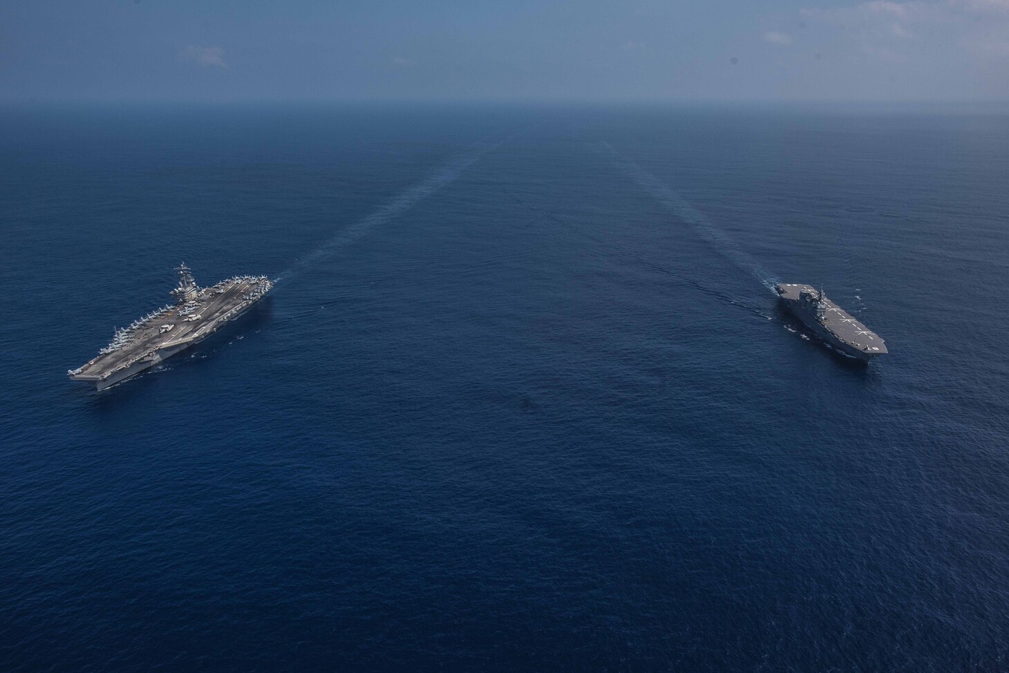 PHILIPPINE SEA (October 9, 2018) The Nimitz-class aircraft carrier USS Ronald Reagan (CVN 76) and the helicopter destroyer JS Izumo (DDH 183) sail alongside each other during a cooperative deployment. Ronald Reagan is forward-deployed to the U.S. 7th fleet area of operations in support of security and stability in the Indo-Pacific region.