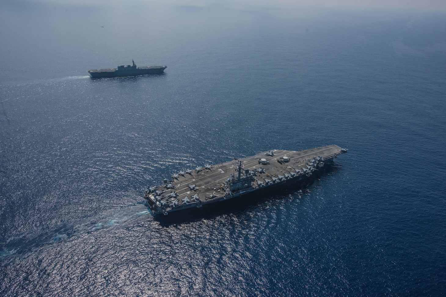 PHILIPPINE SEA (October 9, 2018) The Nimitz-class aircraft carrier USS Ronald Reagan (CVN 76) and the helicopter destroyer JS Izumo (DDH 183) sail alongside each other during a cooperative deployment. Ronald Reagan is forward-deployed to the U.S. 7th fleet area of operations in support of security and stability in the Indo-Pacific region.