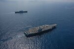 PHILIPPINE SEA (October 9, 2018) The Nimitz-class aircraft carrier USS Ronald Reagan (CVN 76) and the helicopter destroyer JS Izumo (DDH 183) sail alongside each other during a cooperative deployment. Ronald Reagan is forward-deployed to the U.S. 7th fleet area of operations in support of security and stability in the Indo-Pacific region.