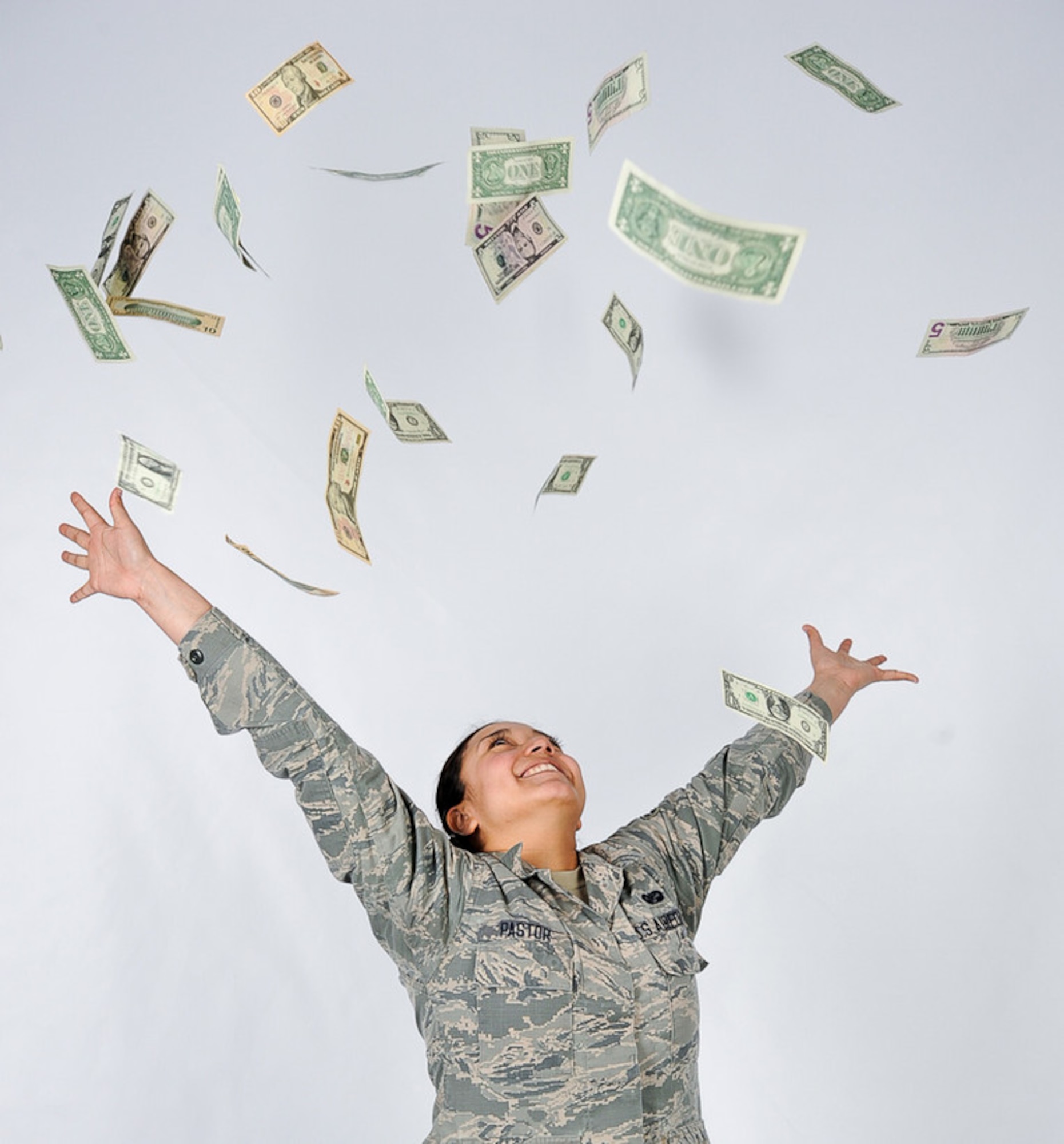 Airman 1st Class Daniela Pastor, 86th Airlift Wing Judge Advocate paralegal, throws money into the air on Ramstein Air Base, April 7, 2017. The Cost of Living Allowance (COLA) Living Pattern Survey (LPS) for Germany will be available on-line from 1 October through 31 October 2018.. (U.S. Air Force photo by Senior Airman Savannah L. Waters)