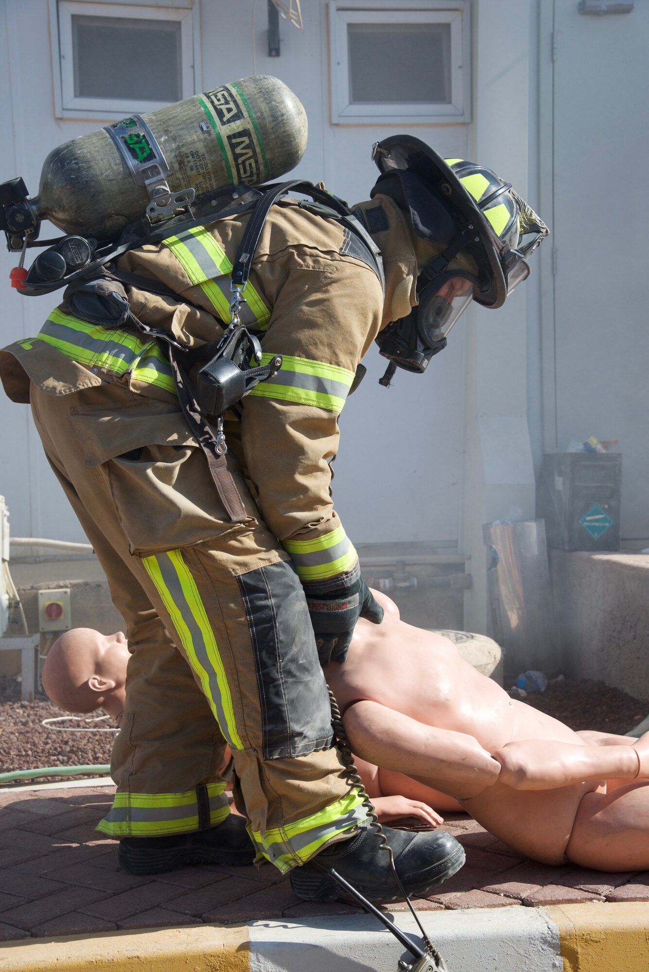 Senior Airman Justin House, 332nd Expeditionary Civil Engineer Squadron Fire Department firefighter, lays down an 80-lb dummy after dragging it out of a building during a simulated fire exercise, Sept. 22, 2018, at an undisclosed location in Southwest Asia. The 332nd CES Fire Department provides fire prevention, firefighting, rescue, and emergency response services for joint and coalition partners here.