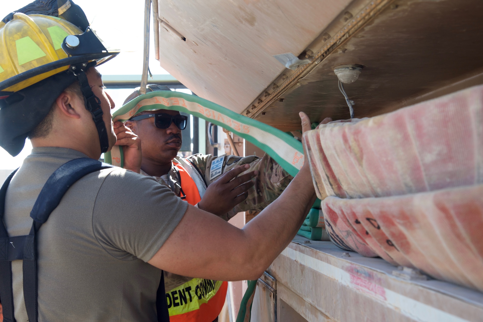Staff Sgt. Johnny Perkins (right) inspects how Tech. Sgt. Danny Lee, both firefighters with the 332nd Expeditionary Civil Engineer Squadron Fire Department, stows a firehose after a simulated fire exercise, Sept. 22, 2018, at an undisclosed location in Southwest Asia. The 332nd CES Fire Department provides fire prevention, firefighting, rescue, and emergency response services for joint and coalition partners here.