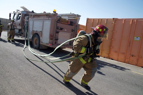 Staff Sgt. Vincent Kinard, 332nd Expeditionary Civil Engineer Squadron Fire Department firefighter, prepares a firehose for a simulated fire during an exercise, Sept. 22, 2018, at an undisclosed location in Southwest Asia.