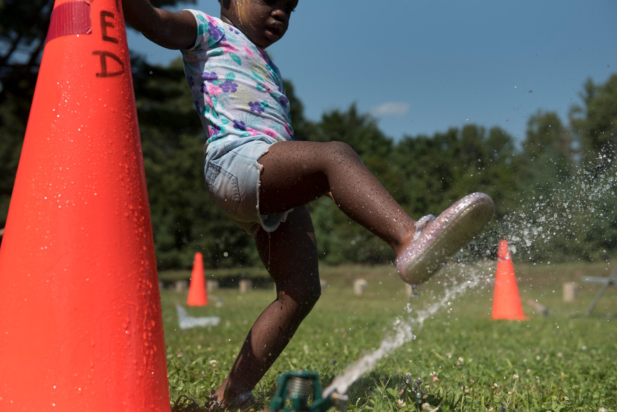 A child playing with water sprinkler during a showcase event hosted by members of Detachment 1, 102nd Medical Group, Otis Air National Guard Base, Mass.. Airmen from Det. 1 invited their family to experience a day in the life of an expeditionary Airman. Volunteers gets to experience how a patient would be treated during a natural disaster through a simulated event.