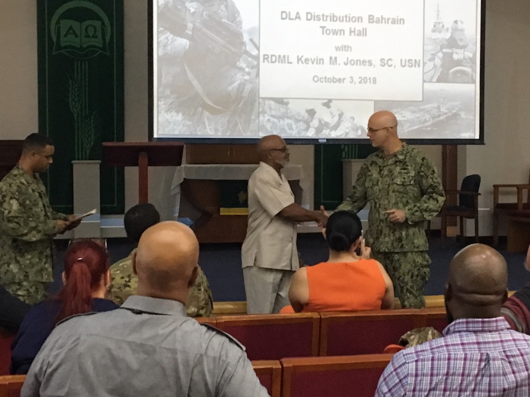 DLA Distribution commanding officer Navy Supply Corps Rear Adm. Kevin Jones recognizes outstanding employees during a town hall at DLA Distribution Bahrain.