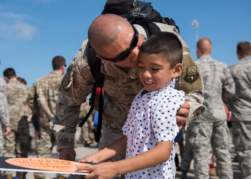 U.S. Air Force Master Sgt. David Gonzalez, 1st Maintenance Squadron production superintendent, kisses his son, David, 6, at Joint Base Langley-Eustis, Virginia, Oct. 9, 2018.