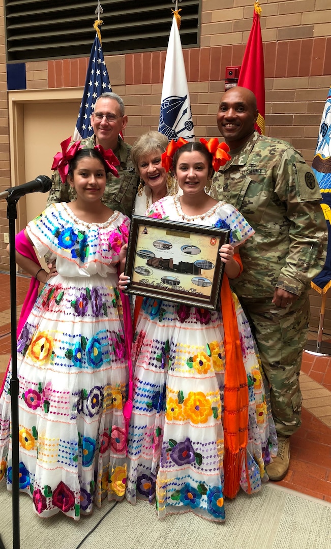Brooke Army Medical Center Commander Brig. Gen. George Appenzeller and BAMC Command Sgt. Maj. Thomas Oates present Karyme Zuniga Reyes and Itzel Schuessler and their teacher, Maria-Cristina Ortega-Alton, a token of appreciation during BAMC’s National Hispanic Heritage Month event in the hospital’s Medical Mall Oct. 3. The group preformed several sings in Spanish to honor different Hispanic and Latino cultures.