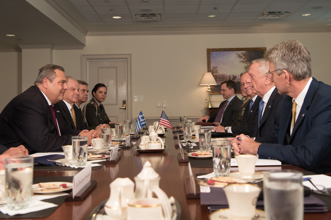 Defense leaders meet at a table at the Pentagon.