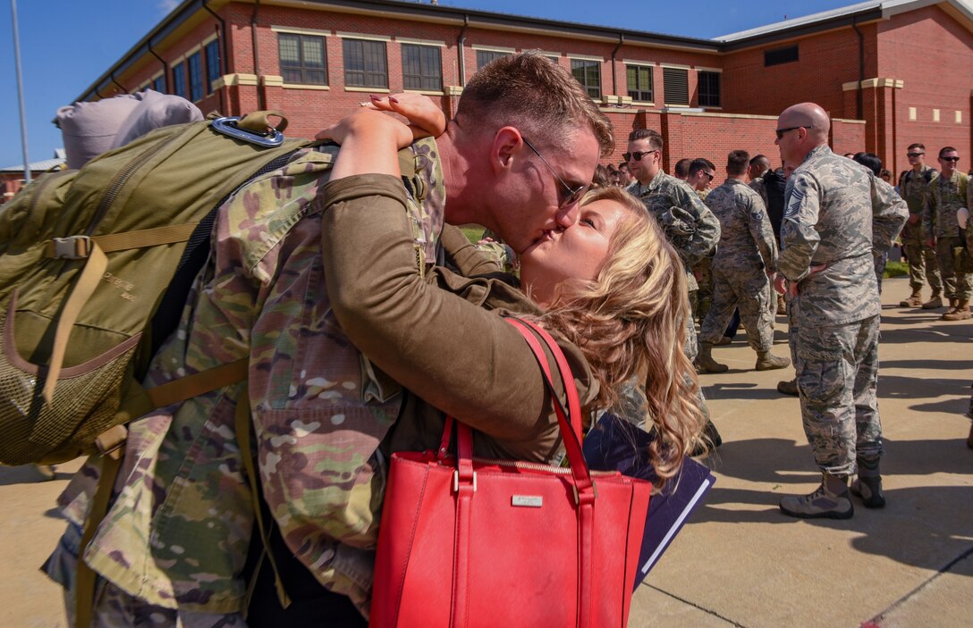 U.S. Air Force Staff Sgt. Justin Smith, 1st Maintenance Squadron load crew chief, kisses his wife Anna after returning to Joint Base Langley-Eustis, Virginia, Oct. 9, 2018. During a 6-month deployment, the U.S. Air Force Airmen and F-22 Raptors delivered air superiority during combat operations, supporting Operation Inherent Resolve and the fight against enemy forces in Iraq and Syria. (U.S. Air Force Photo by Staff Sgt. Carlin Leslie)