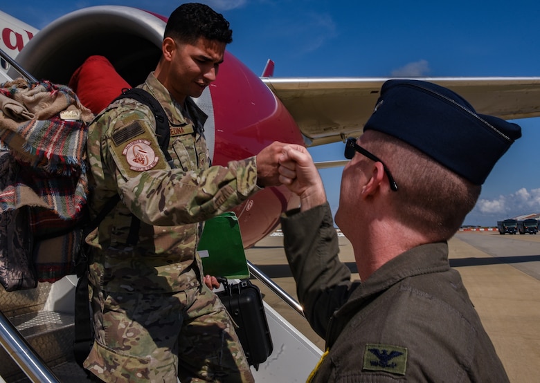 U.S. Air Force Staff Sgt. Israel Medina, 1st Operations Support Squadron aircrew flight equipment, fist bumps Col. Jason Hinds, 1st Fighter Wing commander, after returning to Joint Base Langley-Eustis, Virginia, Oct. 9, 2018.  During a 6-month deployment, the U.S. Air Force Airmen and F-22 Raptors delivered air superiority during combat operations, supporting Operation Inherent Resolve and the fight against enemy forces in Iraq and Syria. (U.S. Air Force Photo by Staff Sgt. Carlin Leslie)