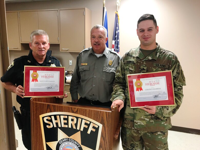 Ken Wenger, Milford Lake park manager, center, presented Geary Co. Sheriff's Deputy Rick Parsons and Pfc. Chance Harriss, stationed at Fort Riley, Kan., with 'Act of Heroism' awards at the Geary County Sheriff's Office October 9, 2018 in Junction City, Kan.