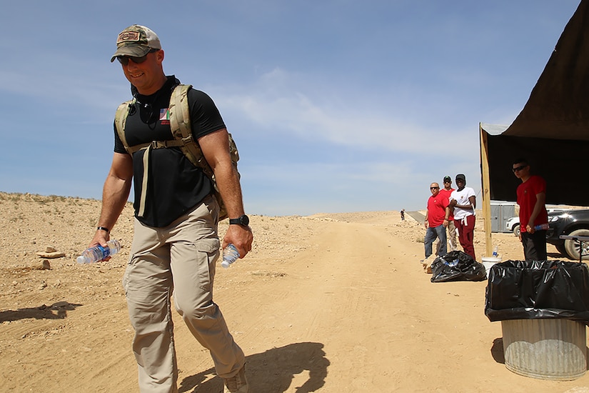 Chief Warrant Officer Three Nathan Heim, with 851st Vertical Engineer Company, 92nd Engineer Battalion, leaves a water point with two more bottles during the March For The Fallen shadow event Oct. 6, 2018. The 28-mile course was comprised of two 14-mile loops with water and refreshment points located roughly every three miles.