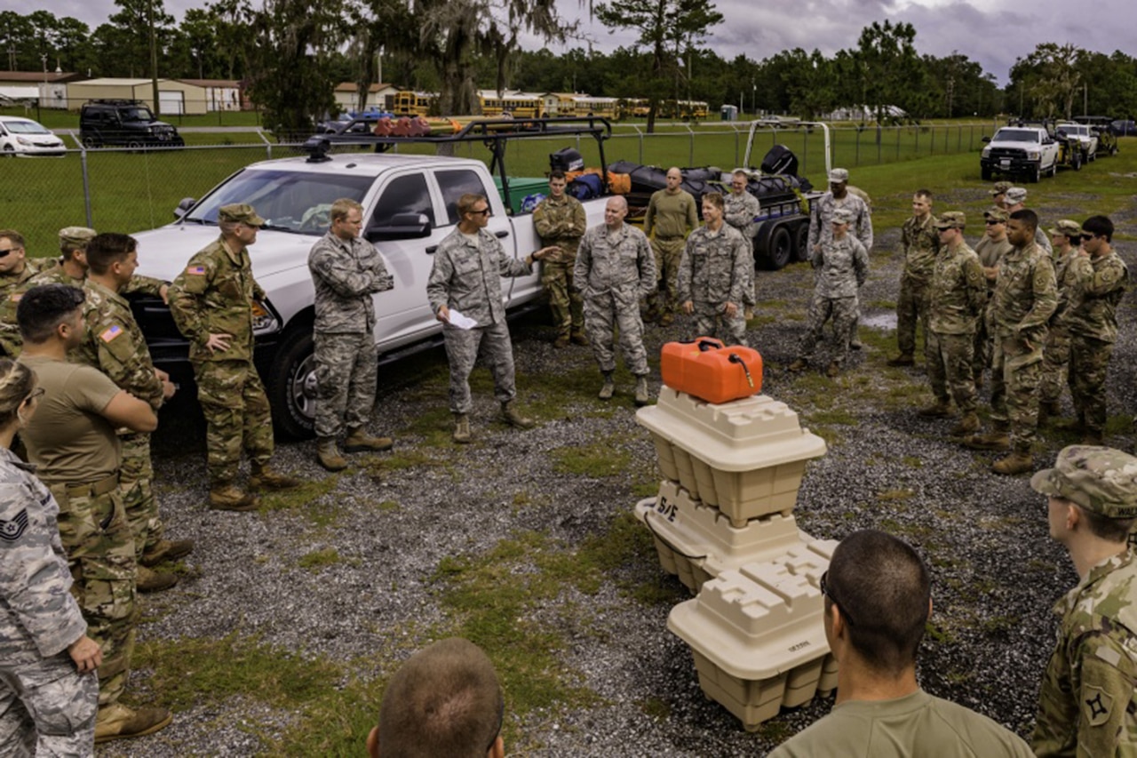 A group of soldiers get briefed.