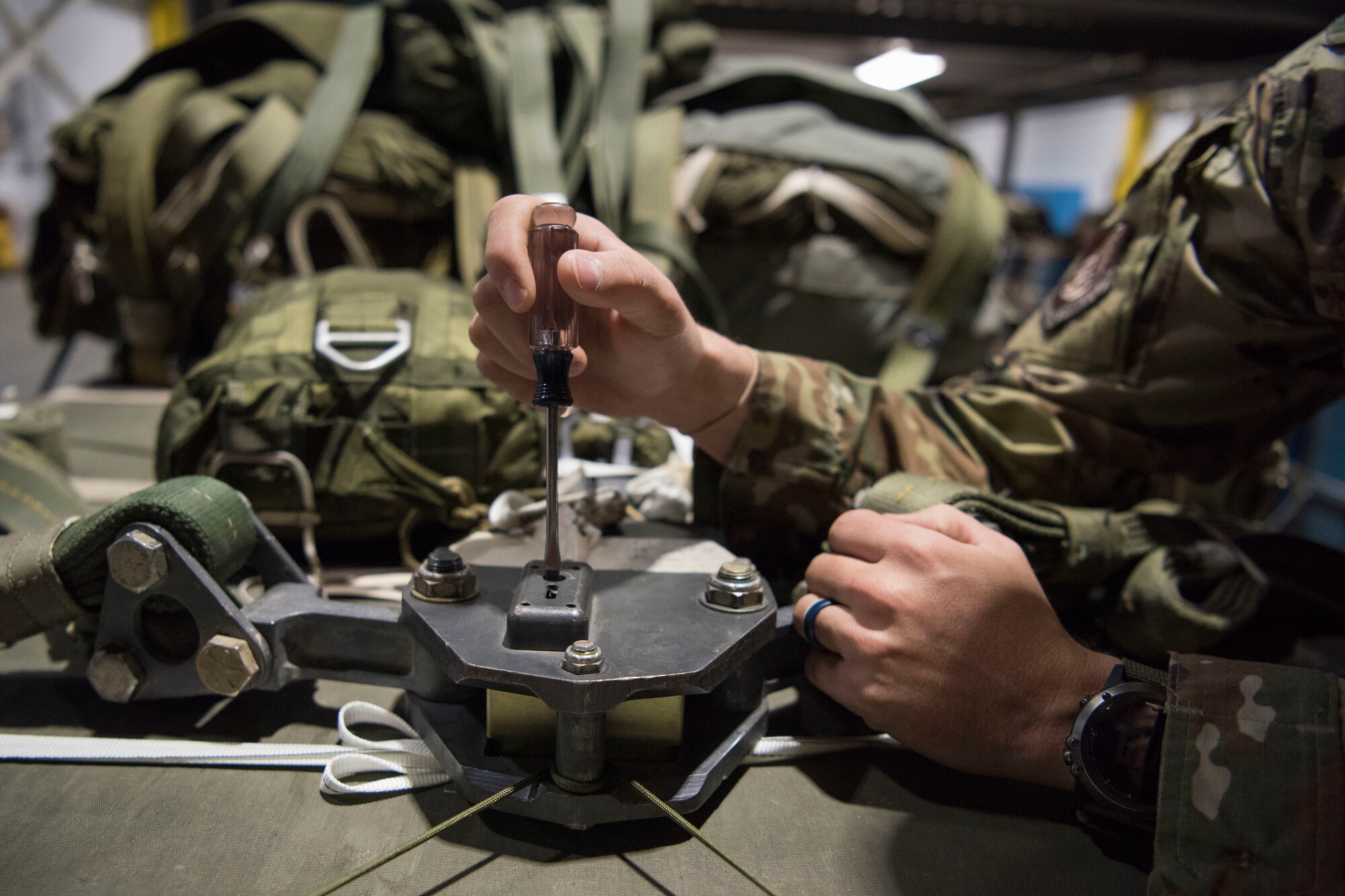 U.S. Air Force Staff Sgt. Douglas Moye, a 773d Logistics Readiness Squadron combat mobility technician supervisor, checks an M-1 parachute release timing block used for heavy cargo platform parachutes at Joint Base Elmendorf-Richardson, Alaska, Oct. 3, 2018. An arming wire sets the timing blocks off, once the timer hits zero it releases the parachute connector links from the M-1 parachute release system. This allows the main parachutes to separate from the load.