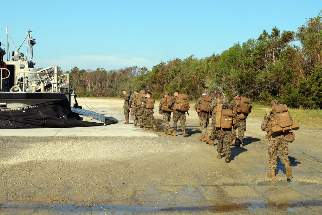 A U.S. Marines prepare to board a Landing Craft Air Cushion at Mile Hammock Bay, Camp Lejeune, North Carolina, Oct. 5, 2018 in preparation to embark aboard USS Iwo Jima (LHD 7) during Type Commander Amphibious Training. TCAT allows the 24th Marine Expeditionary Unit, their subordinate units, and the U.S. Navy’s Iwo Jima Amphibious Ready Group to rehearse ship to shore maneuver and expeditionary command and control prior to exercise Trident Juncture 2018. The goal of TCAT is to increase unit and individual proficiency during amphibious operations. The LAVs are with 2nd Light Armored Reconnaissance Battalion, 24th Marine Expeditionary Unit.  (U.S. Marine Corps photo by Gunnery Sgt. Robert Durham/released)