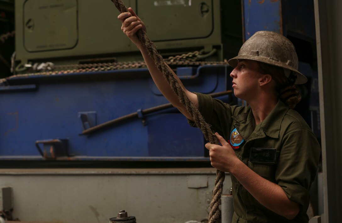 A U.S. Marine with II Marine Expeditionary Force pulls rope to steady the vehicle lift inside USNS Wright (T-AVB 3) before embarkation to Norway in the Port of Morehead City in Beaufort, N.C., Sept. 28, 2018. These vehicles will be used as part of II MEFs participation in the NATO-led Exercise Trident Juncture 18 in Norway, Sweden, Finland, and Iceland. Trident Juncture 18 enhances the U.S. and NATO Allies’ abilities to work together collectively to conduct military operations under challenging conditions. Trident Juncture will include more than 14,000 U.S. service members and 31 Allied and partner nations, totaling more than 40,000 NATO troops. (U.S. Marine Corps photo by Lance Cpl. Samuel Lyden)