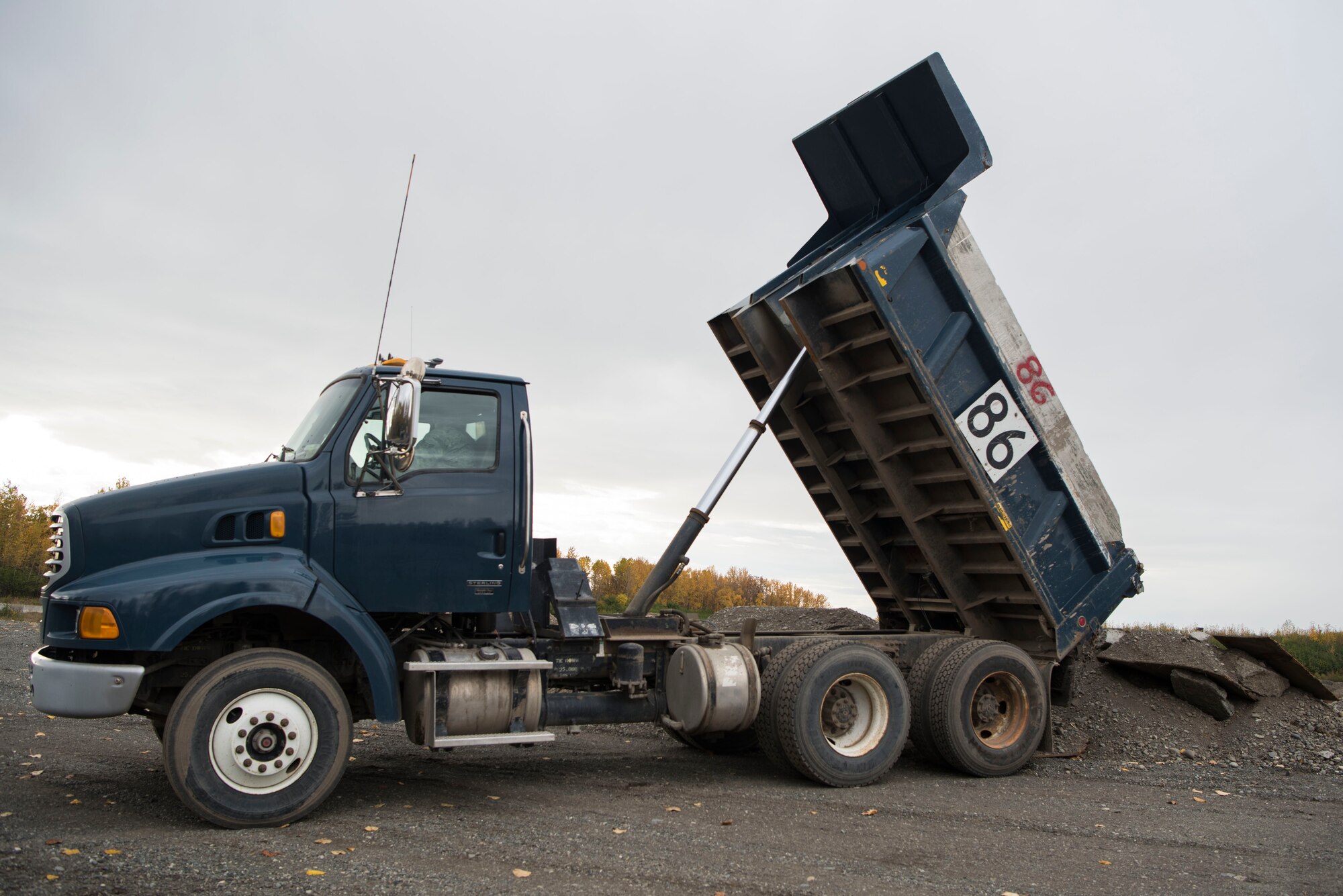 U.S. Air Force Airman 1st Class Shane Leaphart, 773d Civil Engineer Squadron engineer assistant, unloads a dump truck at Joint Base Elmendorf-Richardson, Alaska, Oct. 3, 2018. The 773d CES snow barn personnel train augmentees on properly operating snow-removal equipment, in preparation for the coming winter.