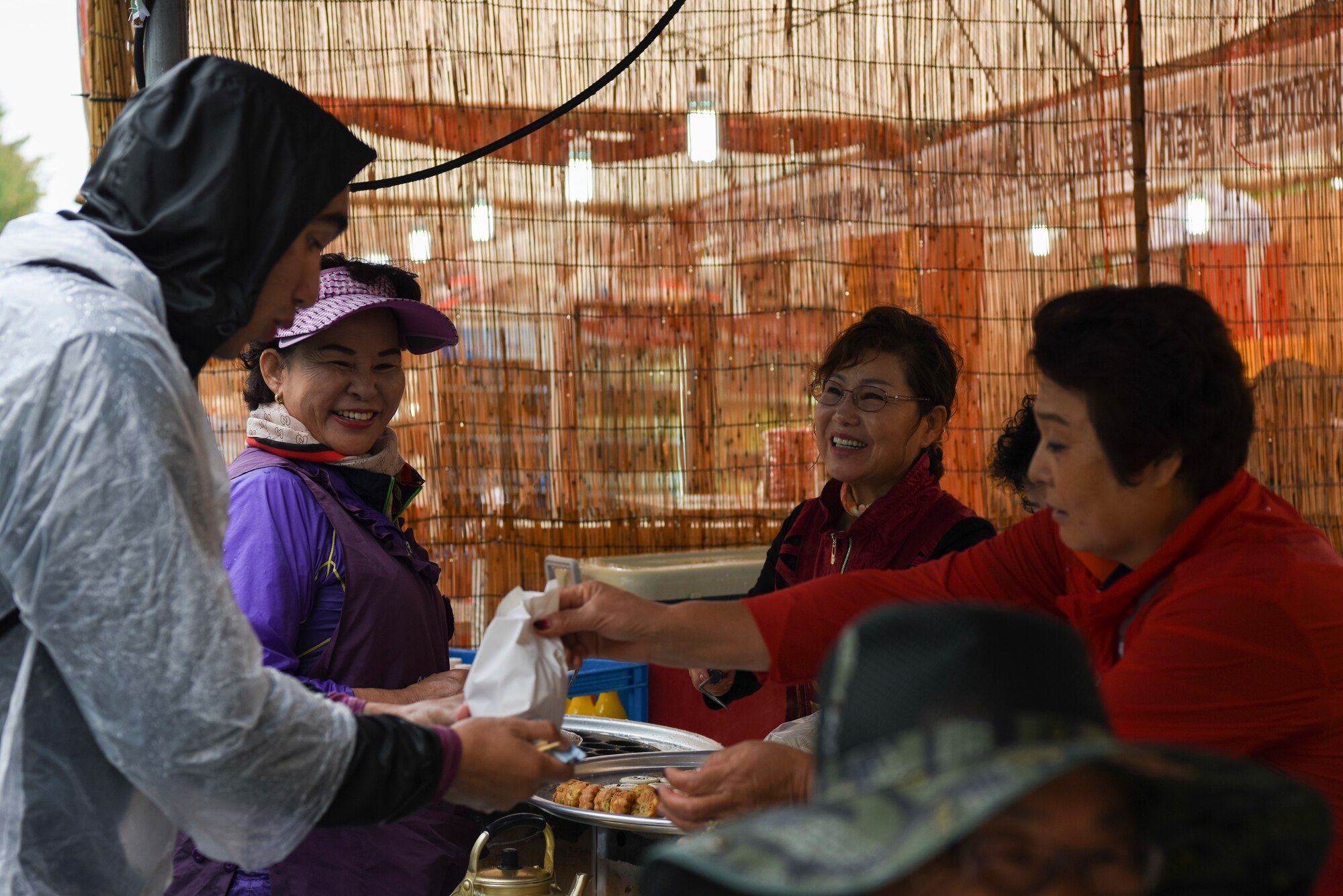 U.S. Air Force Airman Coronel Bruna, 8th Civil Engineering Squadron geobase technician, purchases food from a vendor at the Gimje Horizon Festival, Republic of Korea, Oct. 5, 2018. Gimje is known for its production of a specific high-quality rice, and Airmen from Kunsan Air Base had an opportunity to visit the area and tour the festival. (U.S. Air Force photo by Senior Airman Savannah L. Waters)