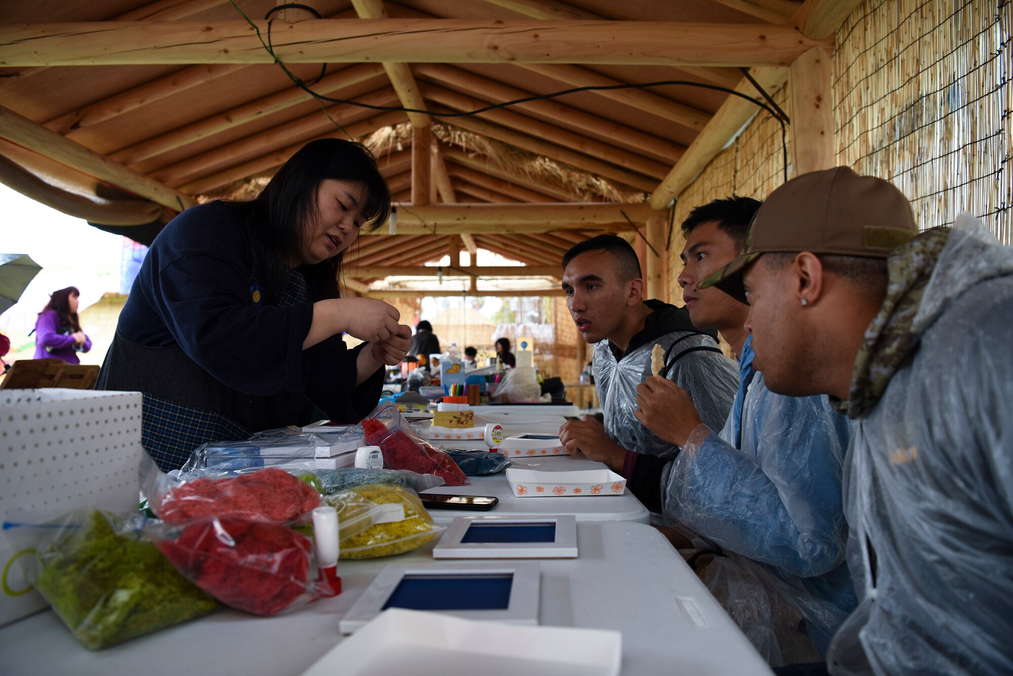 Airmen from Kunsan Air Base, Republic of Korea, watch an instructor demonstrate how to make a craft at an arts and crafts booth at the Gimje Horizon Festival Oct. 5, 2018. Airmen and locals alike were able to enjoy the annual celebration of the rice harvest and learn more about the local community. (U.S. Air Force photo by Senior Airman Savannah L. Waters)