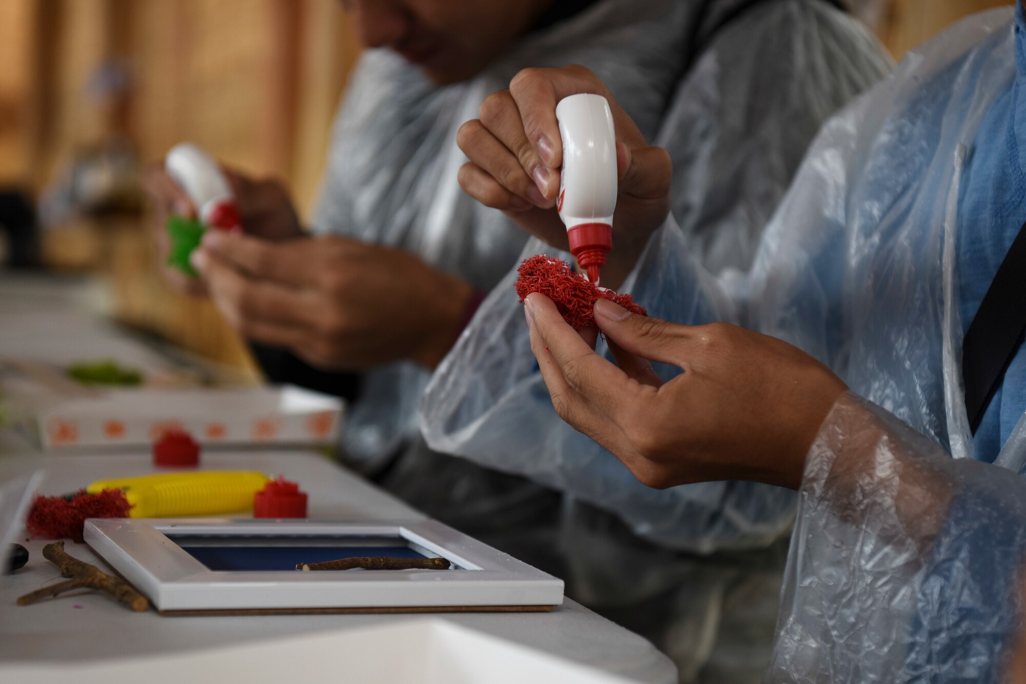 U.S. Air Force Airman Rustom Jay Lopez, 8th Civil Engineering Squadron geobase technician, applies glue to colored moss at an arts and crafts booth at the Gimje Horizon Festival, Republic of Korea, Oct. 5, 2018. Gimje is known for its production of a specific high-quality rice, and Airmen from Kunsan Air Base had an opportunity to visit the area and tour the festival. (U.S. Air Force photo by Senior Airman Savannah L. Waters)