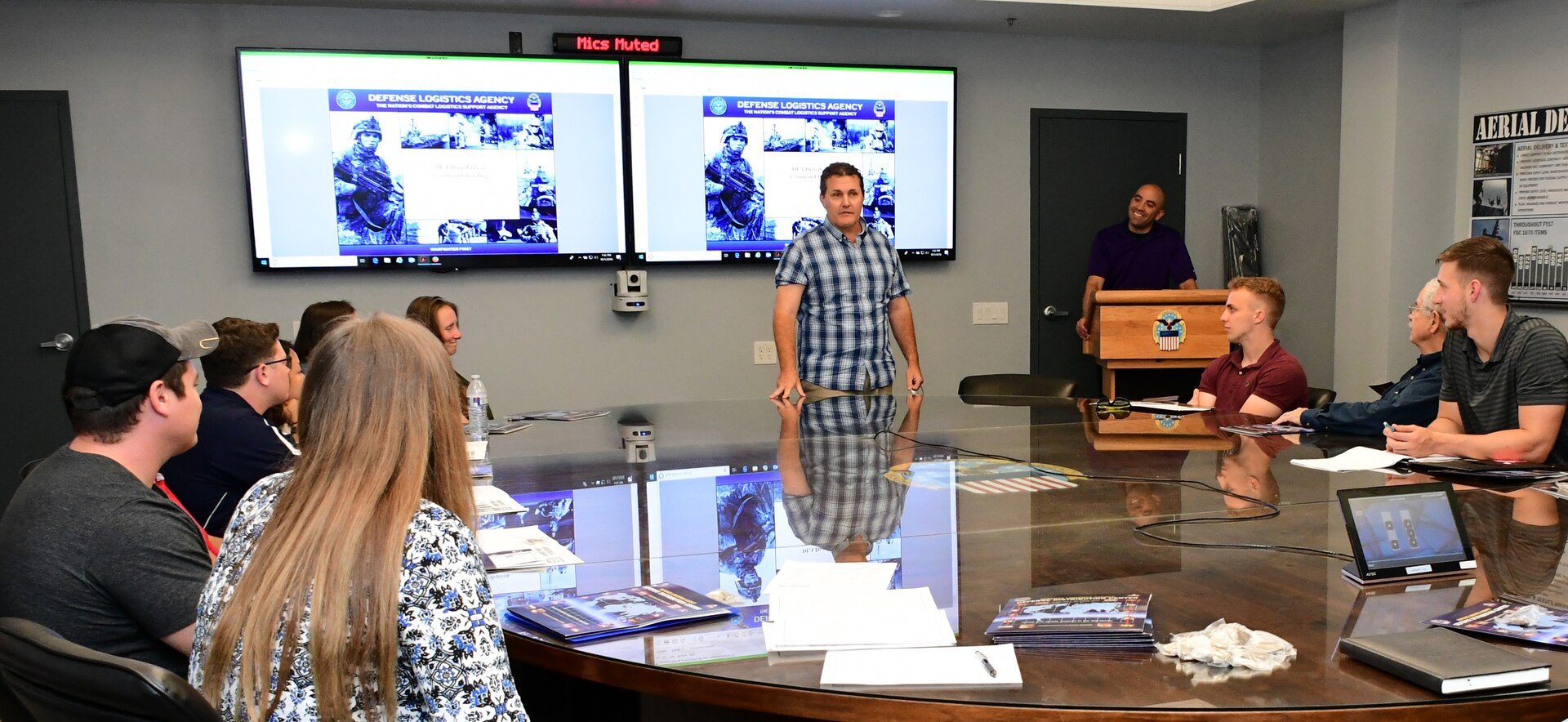 Bret Barnes, deputy commander, DLA Distribution Susquehanna, Pennsylvania, discusses warehouse operations with APICS members prior to their walking tour of the Eastern Distribution Center Oct. 1.