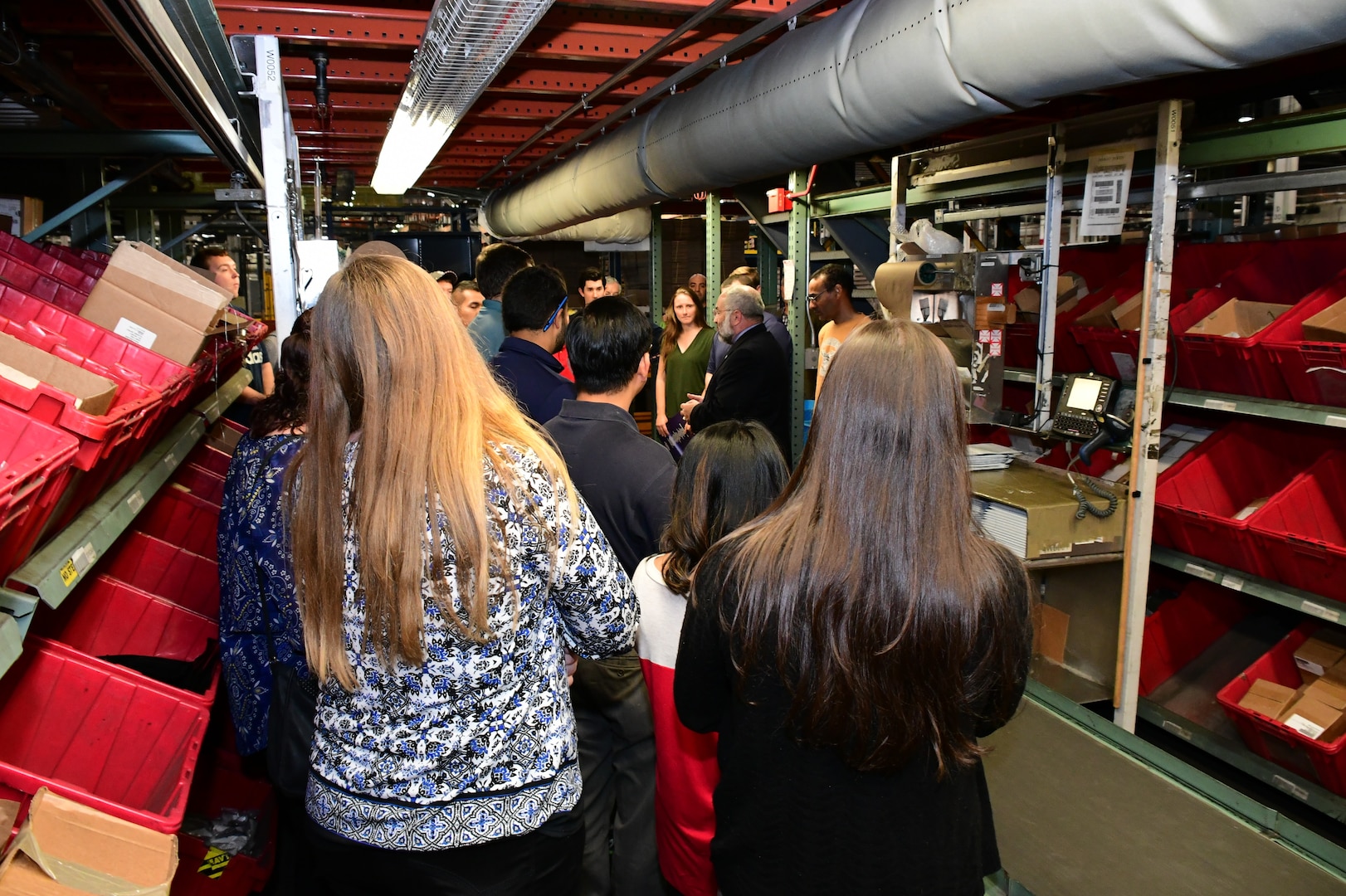 APICS members listen as the Walk and Pick operations are detailed during their walking tour of the Eastern Distribution Center, DLA Distribution Susquehanna, Pennsylvania.